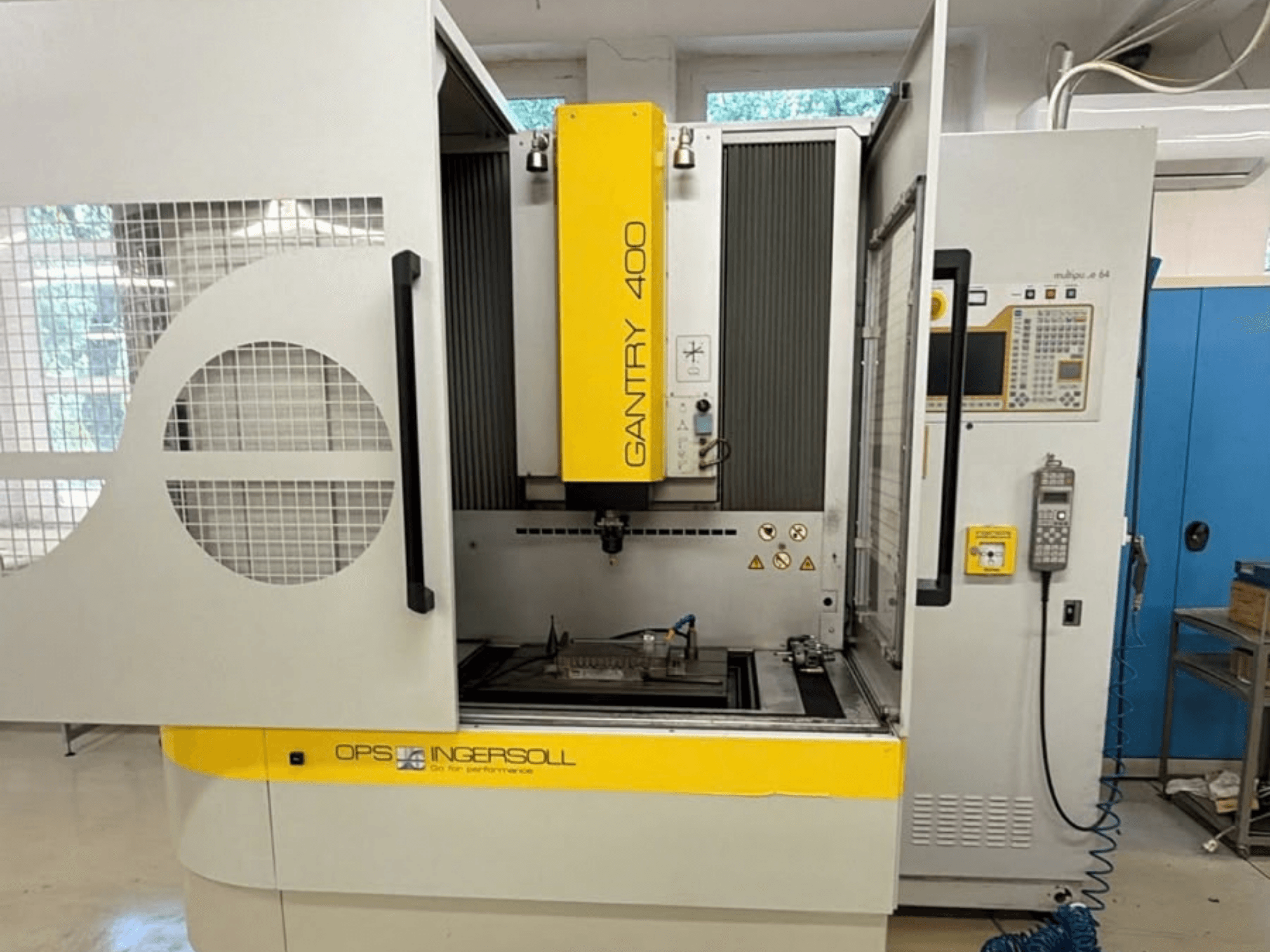 INGERSOLL Gantry 400 Kalıp Delme EDM Makinesinin önden görünümü; kapılar açık ve kontrol paneli görünür durumda, iş parçası ise makinenin içinde konumlandırılmış.