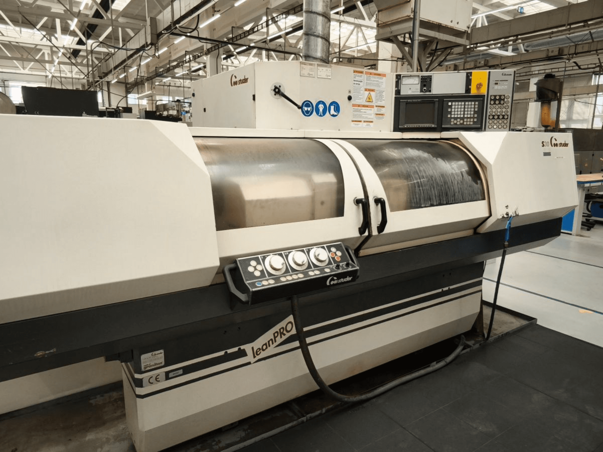 STUDER S30 LEAN PRO silindirik taşlama makinesi, yandan görünüm, endüstriyel bir ortamda kontrol panelini ve taşlama taşı kapağını gösterir.