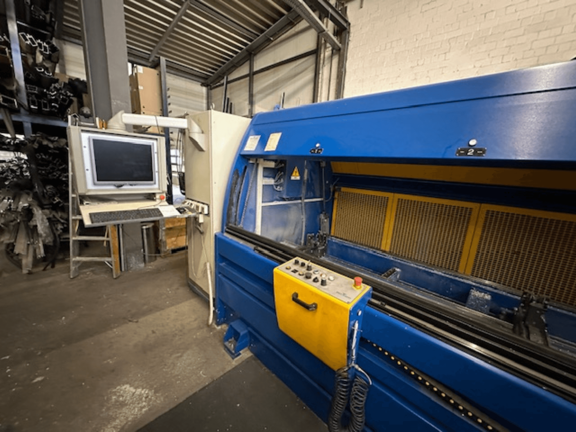 Kontroller ve bilgisayar iş istasyonu ile evrensel bir işleme merkezi olan SCHÜCO Profilbearbeitungscenter 299 650'nin önden görünümü.