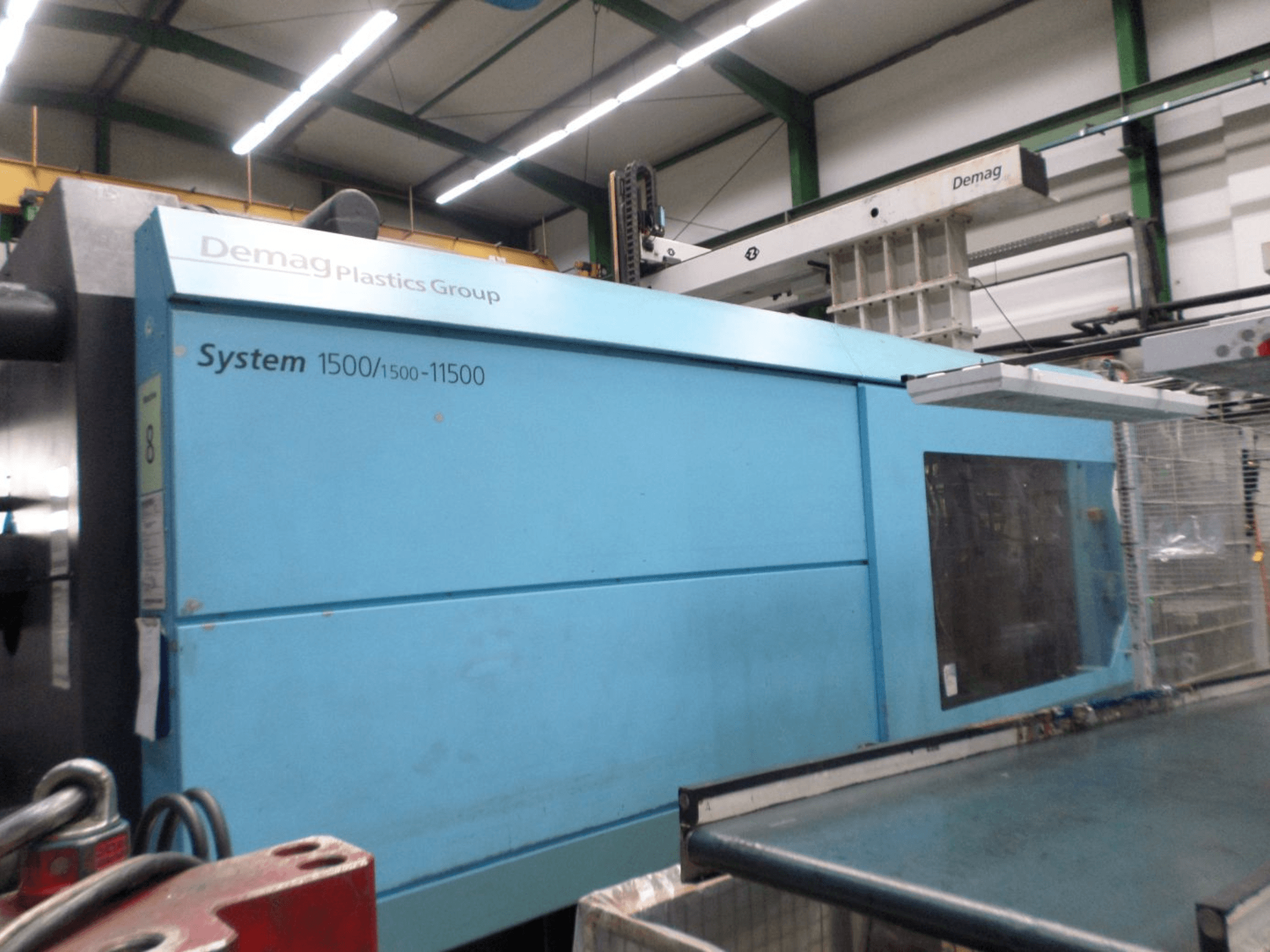 Mavi renkli Demag D 650 hidrolik enjeksiyon kalıplama makinesi; System 1500/1500-11500 etiketini ve çalışma alanını gösteren yandan görünüm.