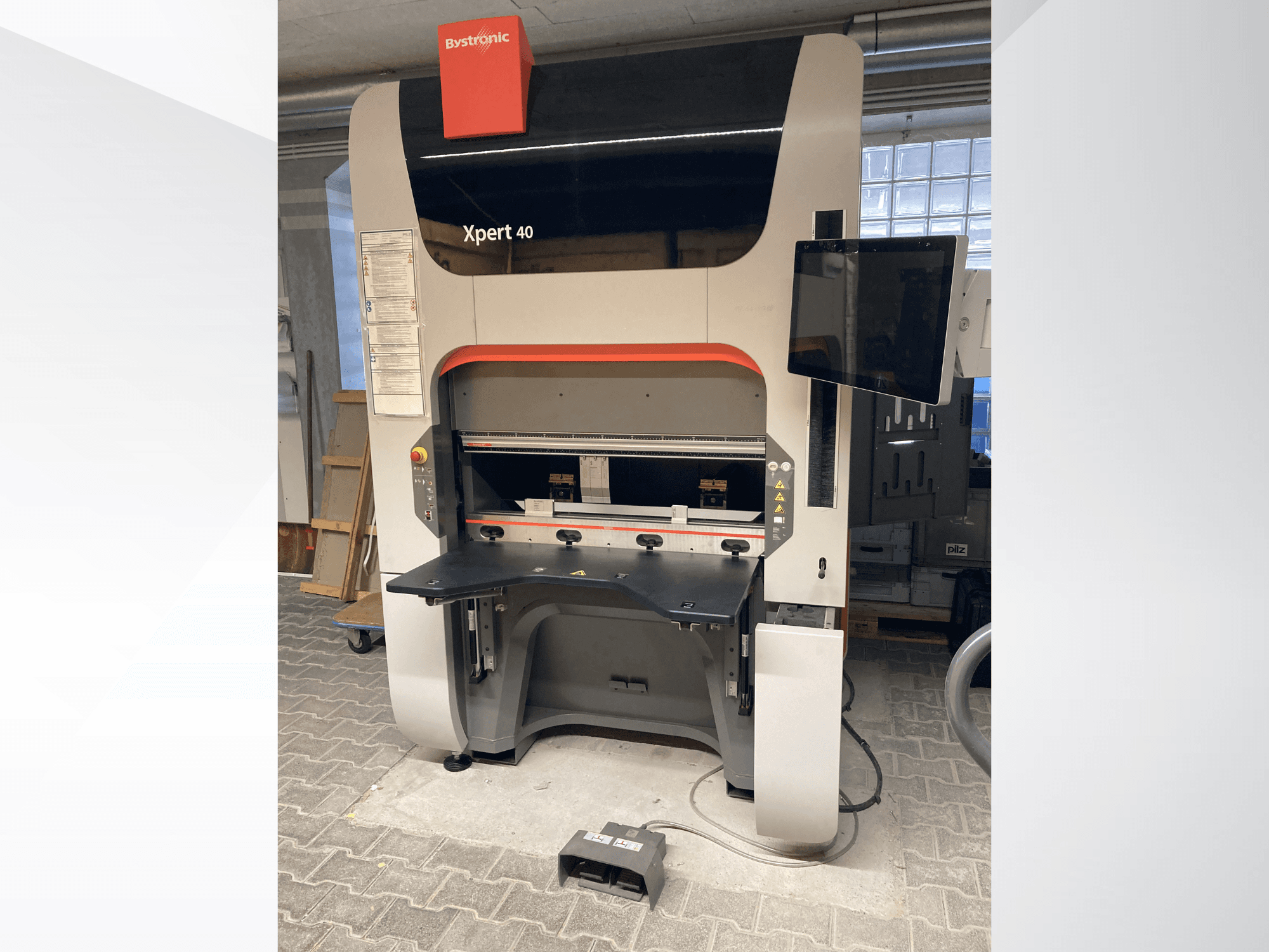 Bystronic Xpert 40/1030 abkant presin önden görünümü, kontrol paneli, çalışma yüzeyi ve bağlı monitör.