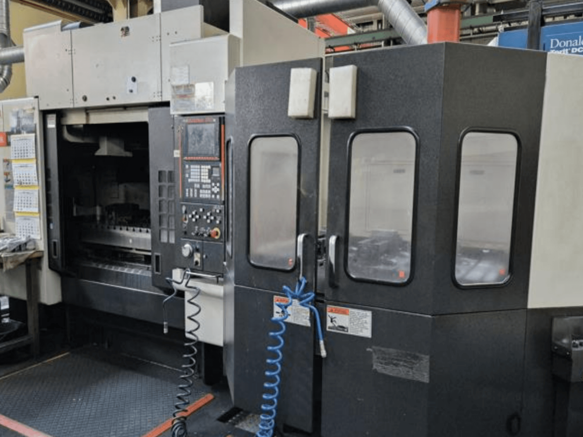 Mazak V515/40N Dik İşleme Merkezinin önden görünümü, kontrol paneli ve kapalı çalışma alanı.