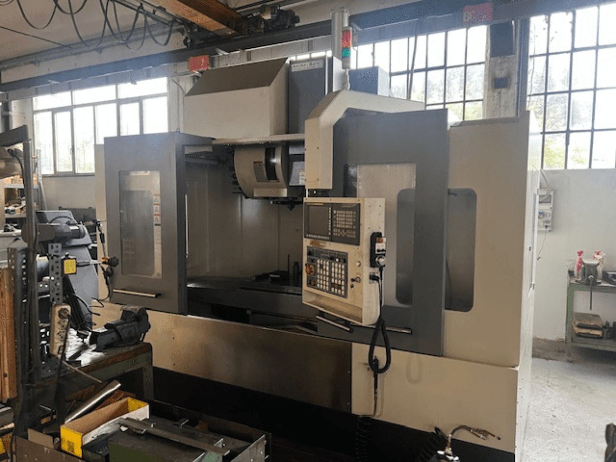 Yüksek teknolojili CNC freze makinesi, önden görünüm, dijital kontroller, temel güvenlik göstergeleri ve kompakt bir tasarım.