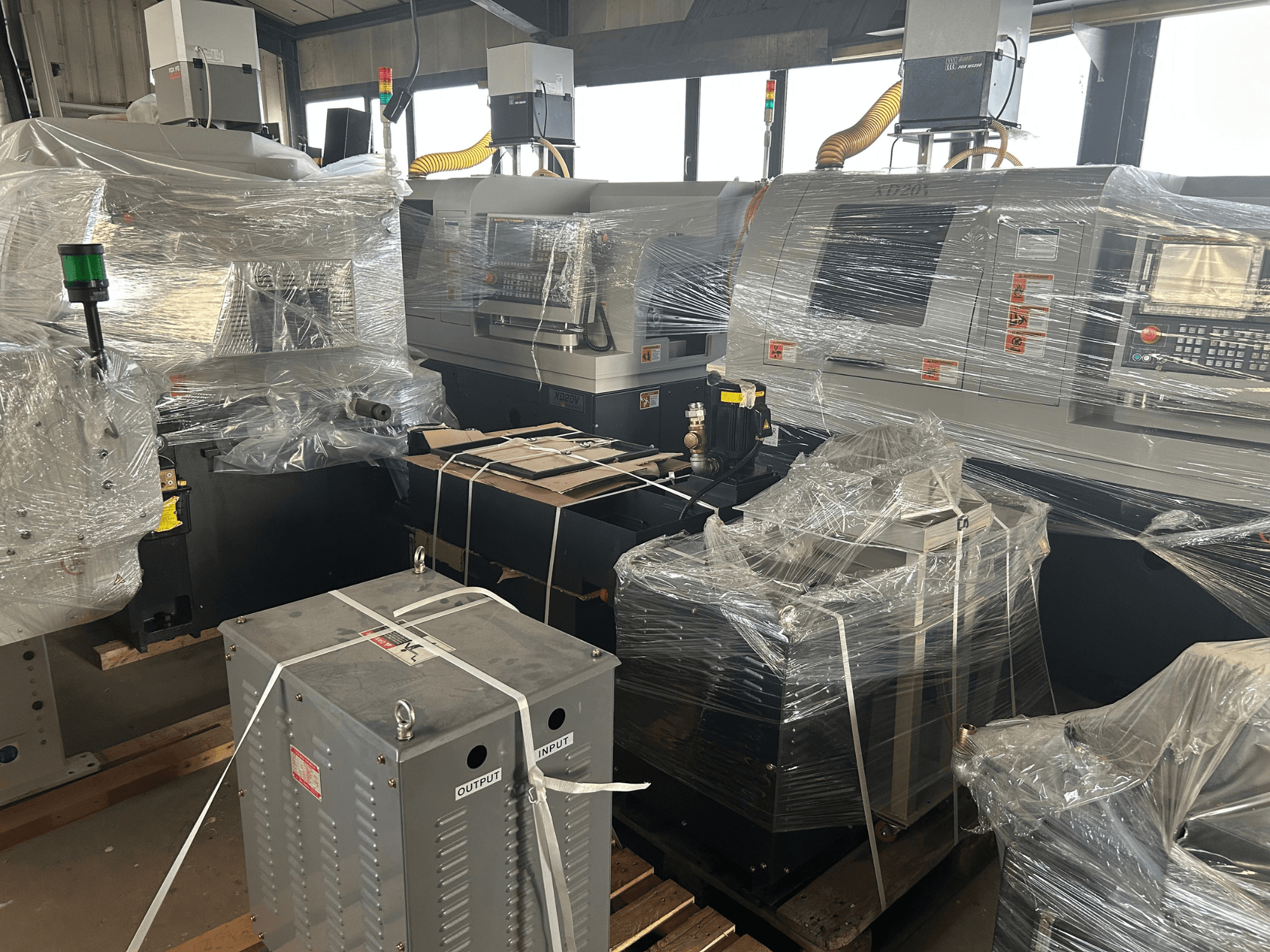 Hanwha XD20V Kombine İsviçre Tipi Torna Makinesi, kısmen sarılmış, kontroller ve makine bileşenleri görülebilecek şekilde yandan gösterilmiştir.