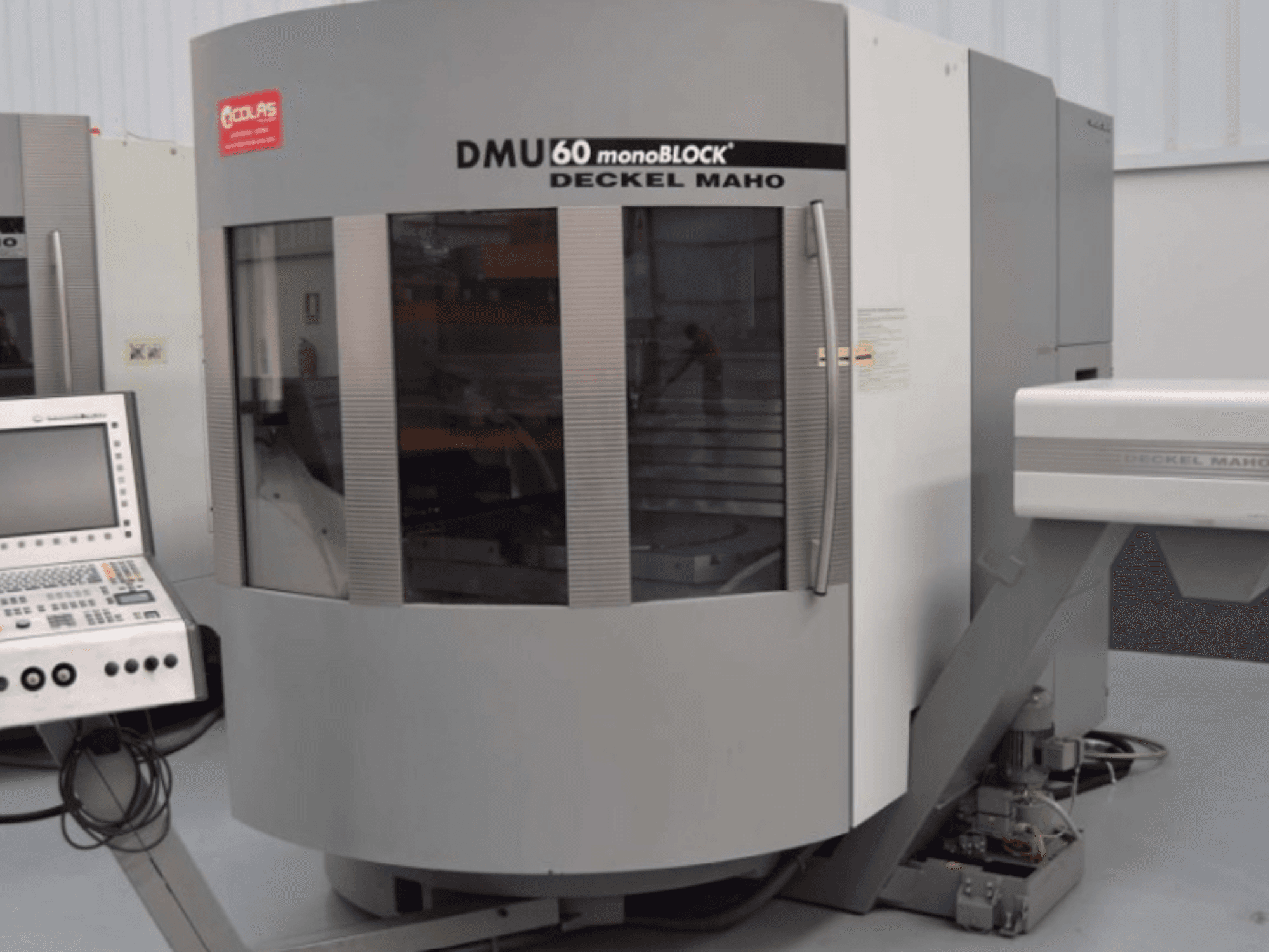 DMG DMU60 Monoblok dikey işleme merkezi; önden görünümde, sol tarafta kontrol paneli görülmektedir.