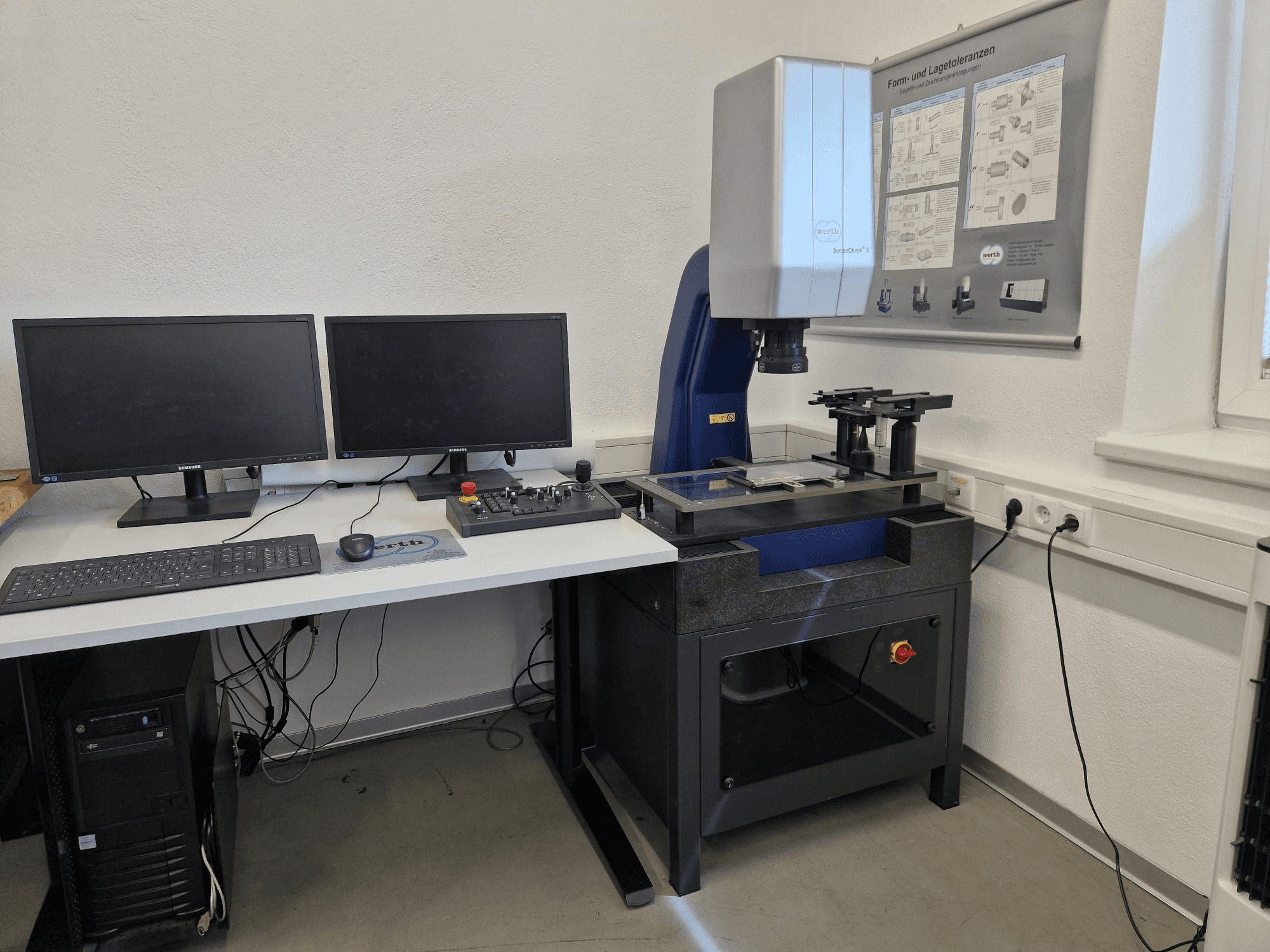 Laboratuvar kurulumunda Werth Scopecheck 300S CMM; bir ölçüm masası, çift monitör ve bir kontrol paneli içerir.