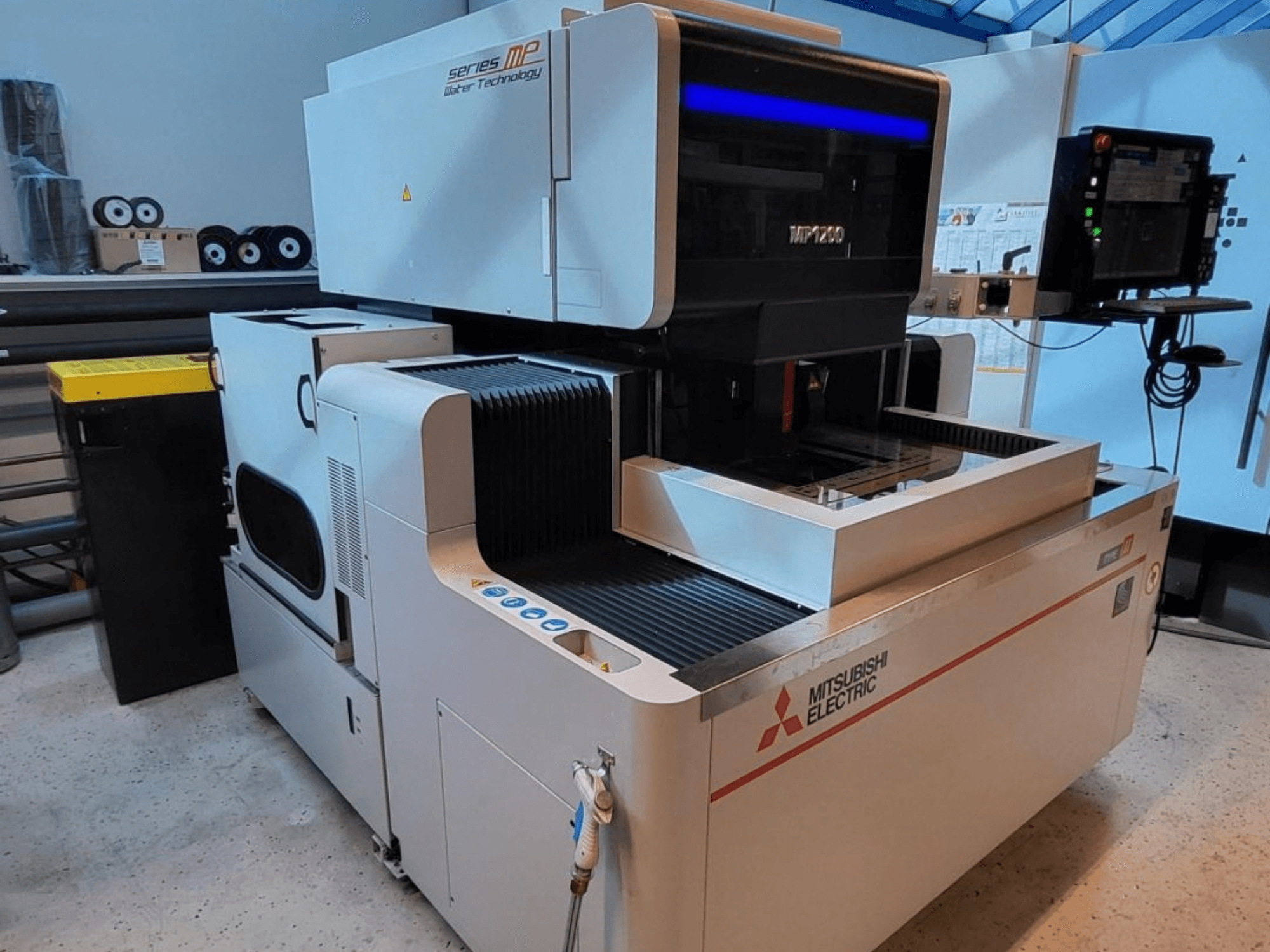 Mitsubishi MP1200 Tel Elektrikli Kesişimli İşleme (EDM) makinesi, önden görünüm; kontrol paneli, son teknoloji detaylar ve şık tasarımıyla dikkat çekiyor.