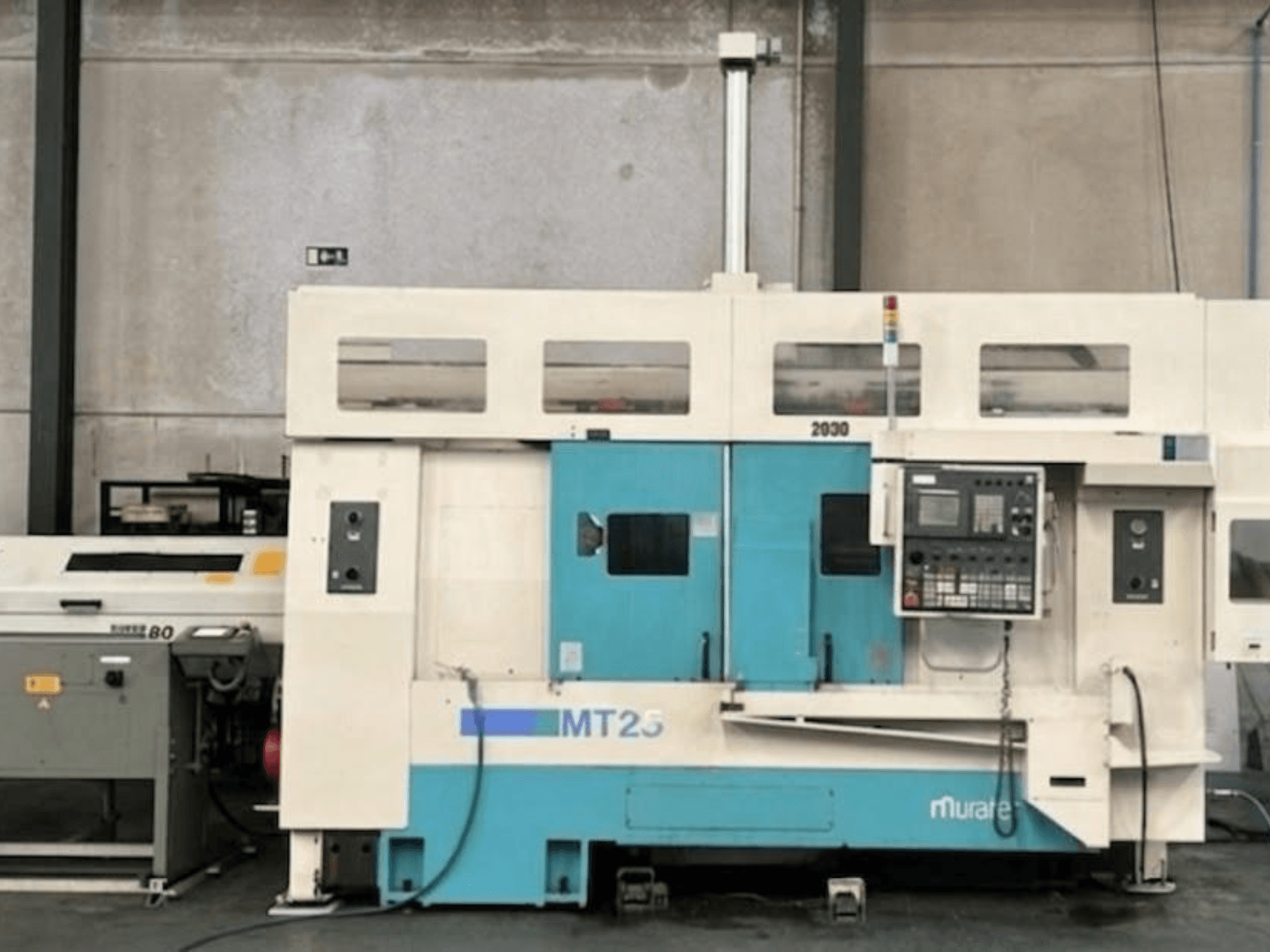 Muratec MT 25 MY torna freze merkezi yandan görünüm, kontrol paneli ve mavi/beyaz dış yüzey.