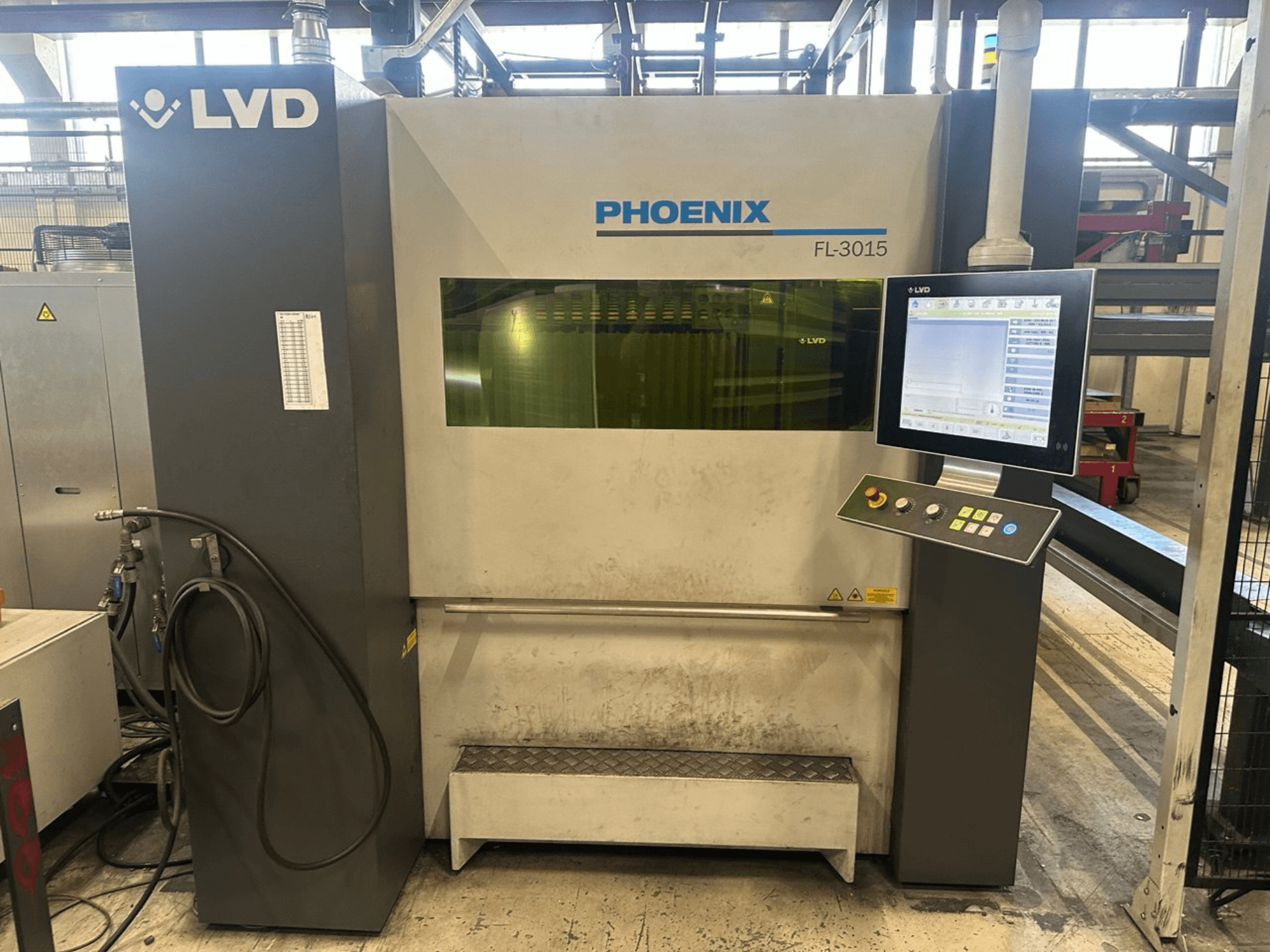 LVD Phoenix FL-3015 lazer kesim makinesi, önden görünüm, dijital kontrol paneli ve görünür hortumlara sahiptir.