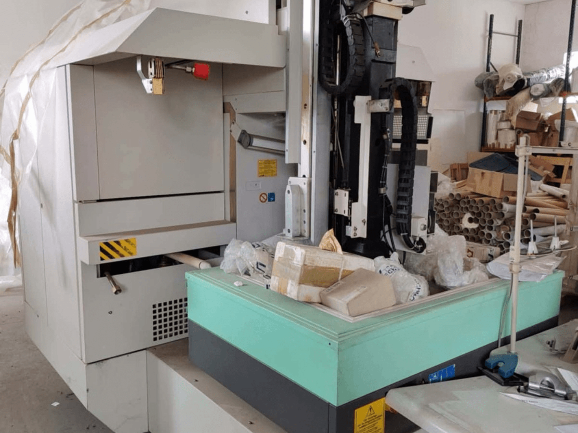 AGIE AGIETRON INTEGRAL 2 kalıp oyma EDM makinesi, önden görünüm, kontrol paneli, çalışma masası ve çevresindeki dağınıklığı gösteriyor.