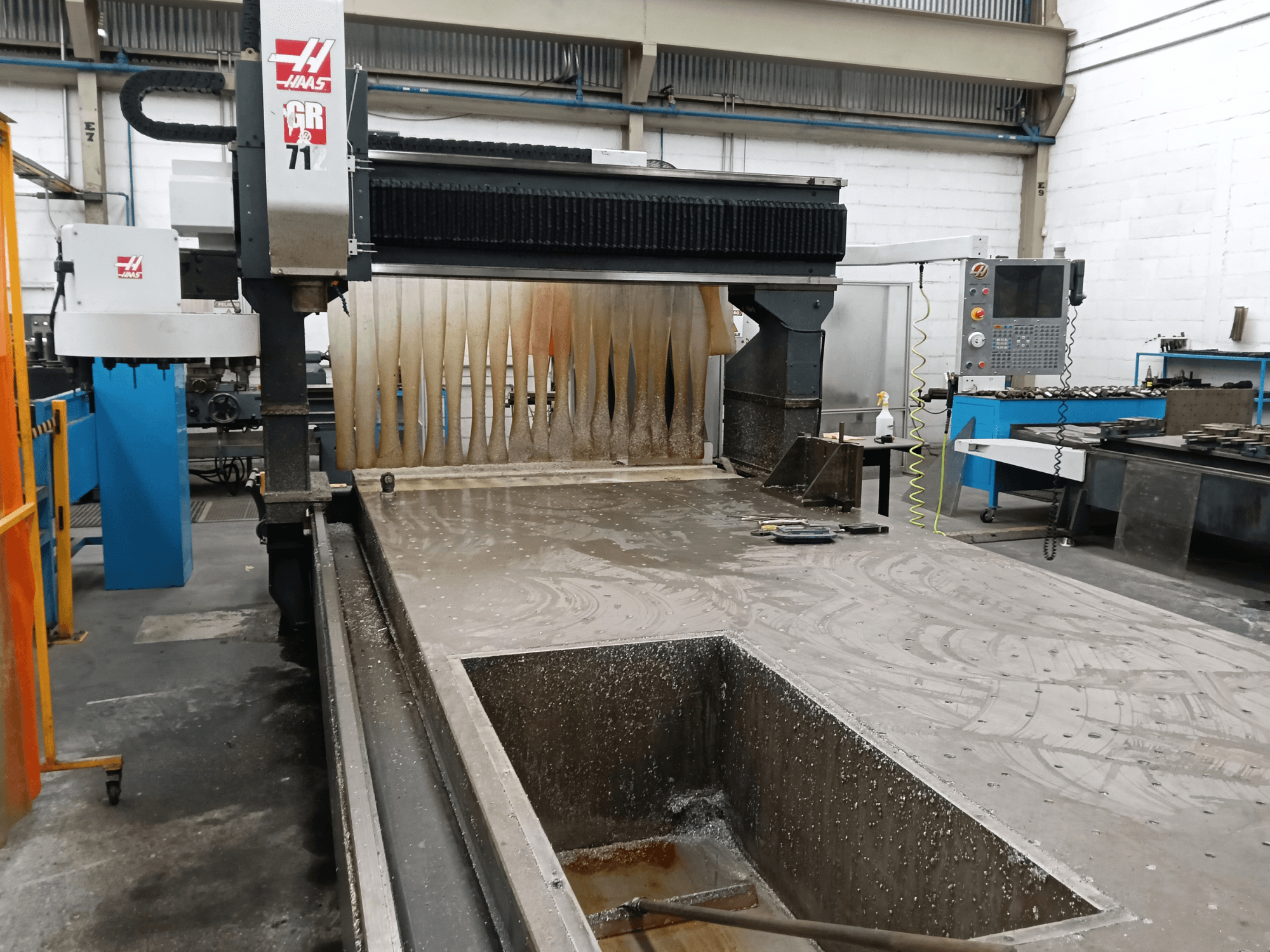 HAAS GR-712 portal freze tezgahı, önden bakıldığında ıslak kesim yüzeyi ve operatör kontrol paneli görülmektedir.