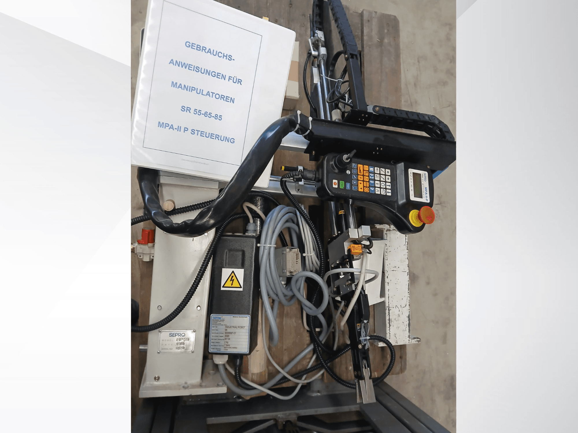 Sepro PIP-55 Gantry Robot kontrol paneli ve bileşenleri, yandan bakıldığında kullanım kılavuzu görünür.