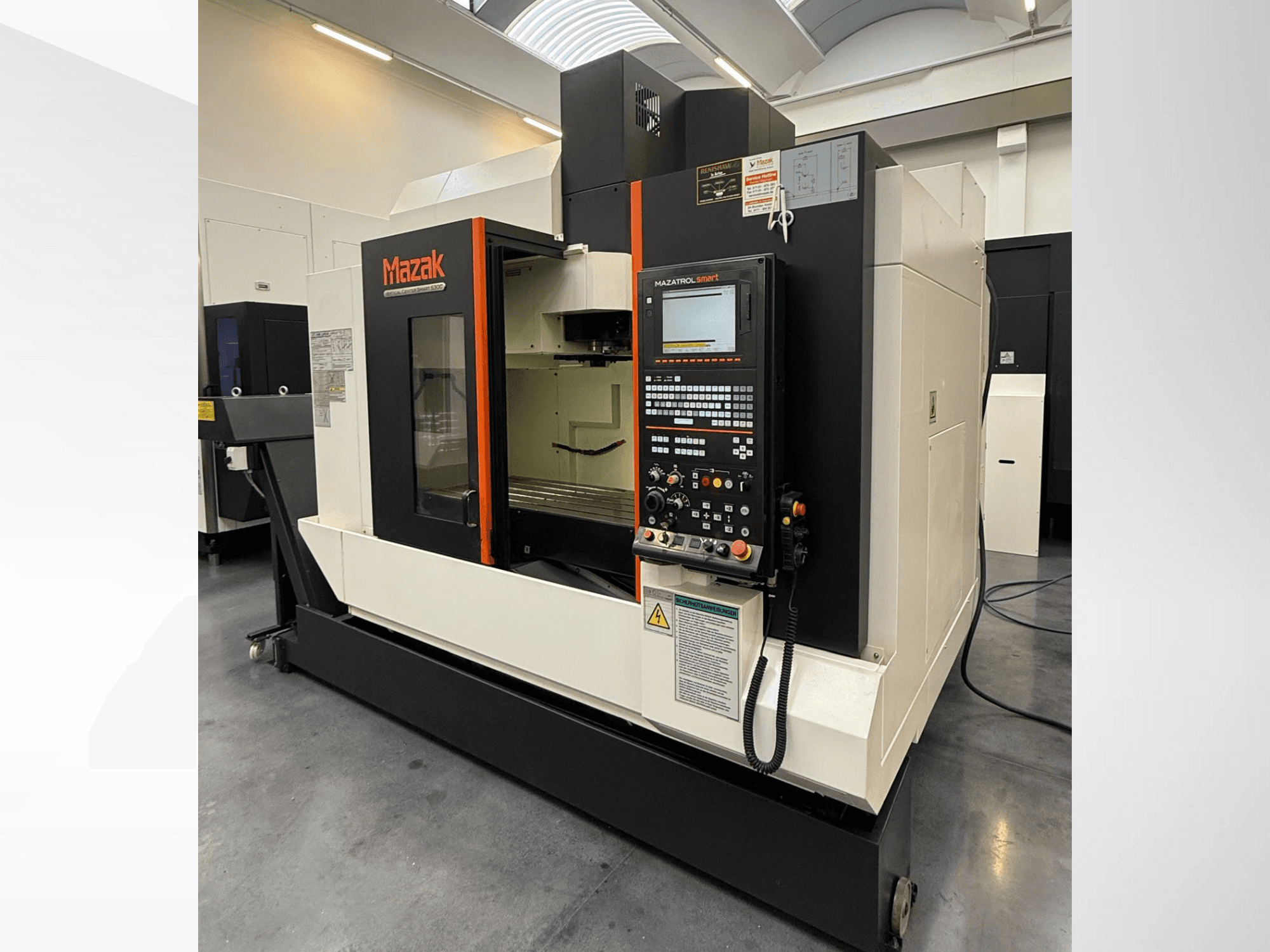 Mazak CNC makinesi, önden görünüm, bir kontrol paneli ve hassas kesme aletleri içeren geniş bir çalışma alanı.