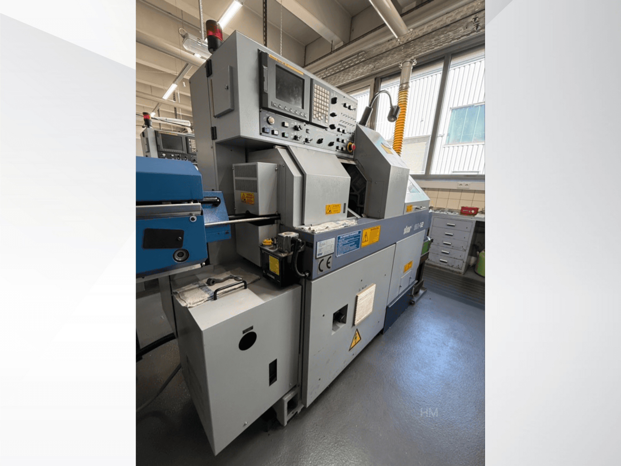 lithec 3231 makinesinin önden görünümü, iyi aydınlatılmış endüstriyel bir ortamda kontrol panelini, motoru ve mavi besleme bölümünü göstermektedir.