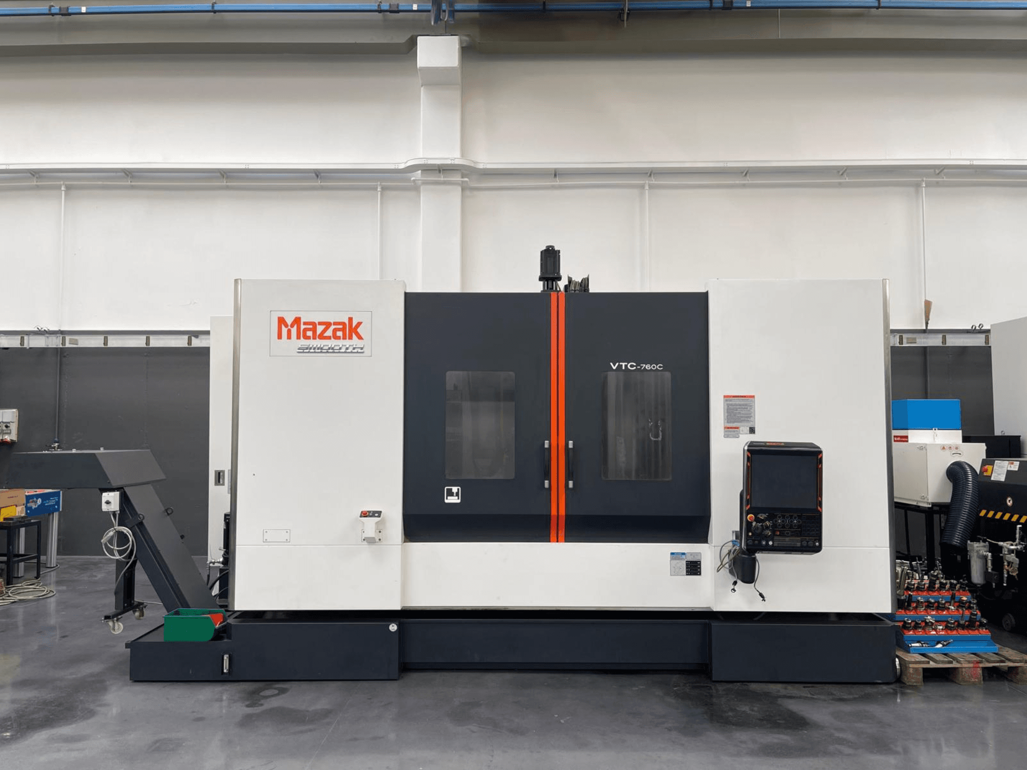 Mazak VTC 760C Dikey İşleme Merkezi, kontrolleri gösteren yandan görünüm, beyaz ve siyah dış yüzey ve turuncu vurgular.