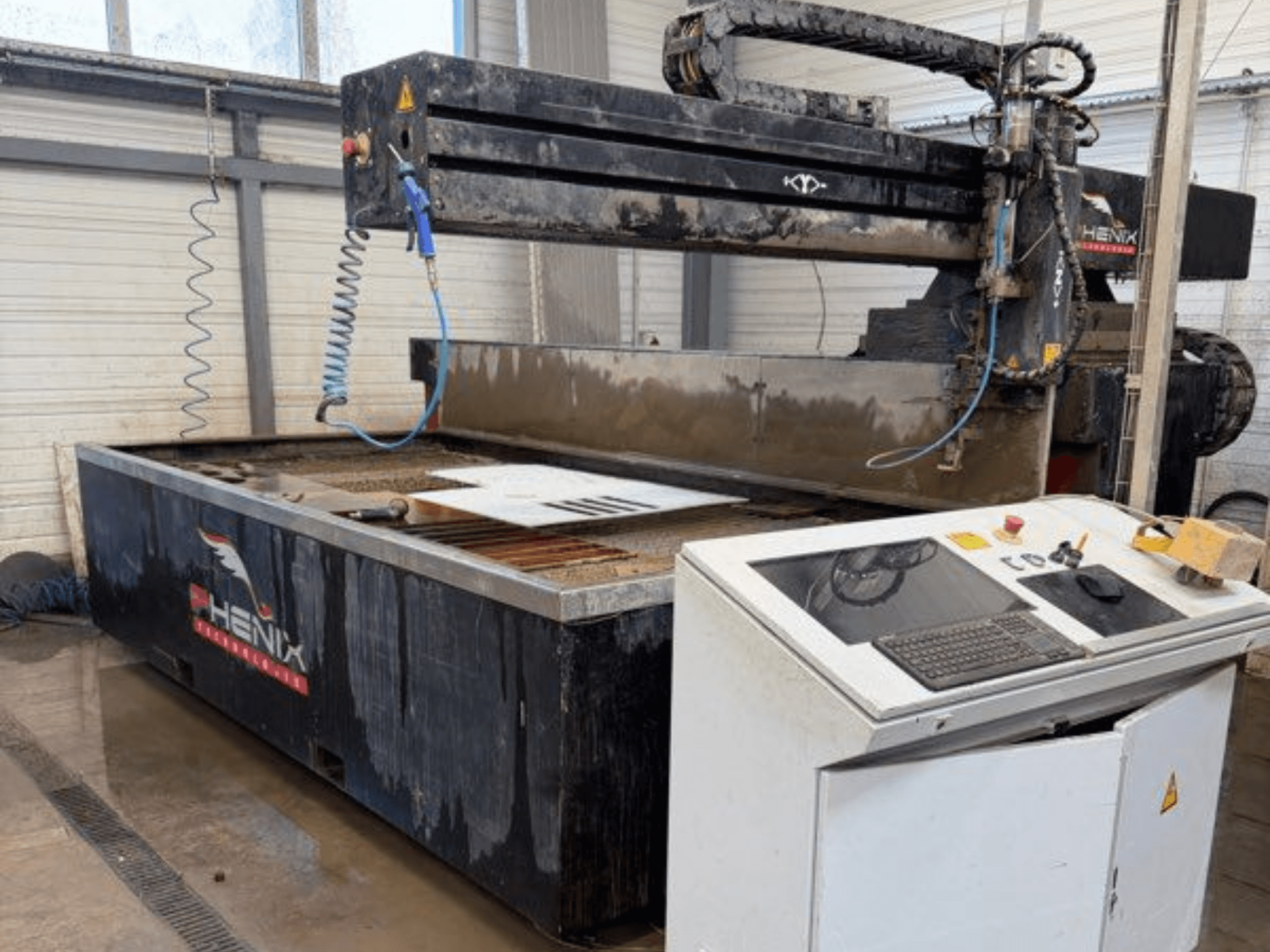 PHENIX MD JET 1530 su jeti kesim makinesi, kontrol panelini ve görünür su tankı ile kesim alanını gösteren önden görünüm.