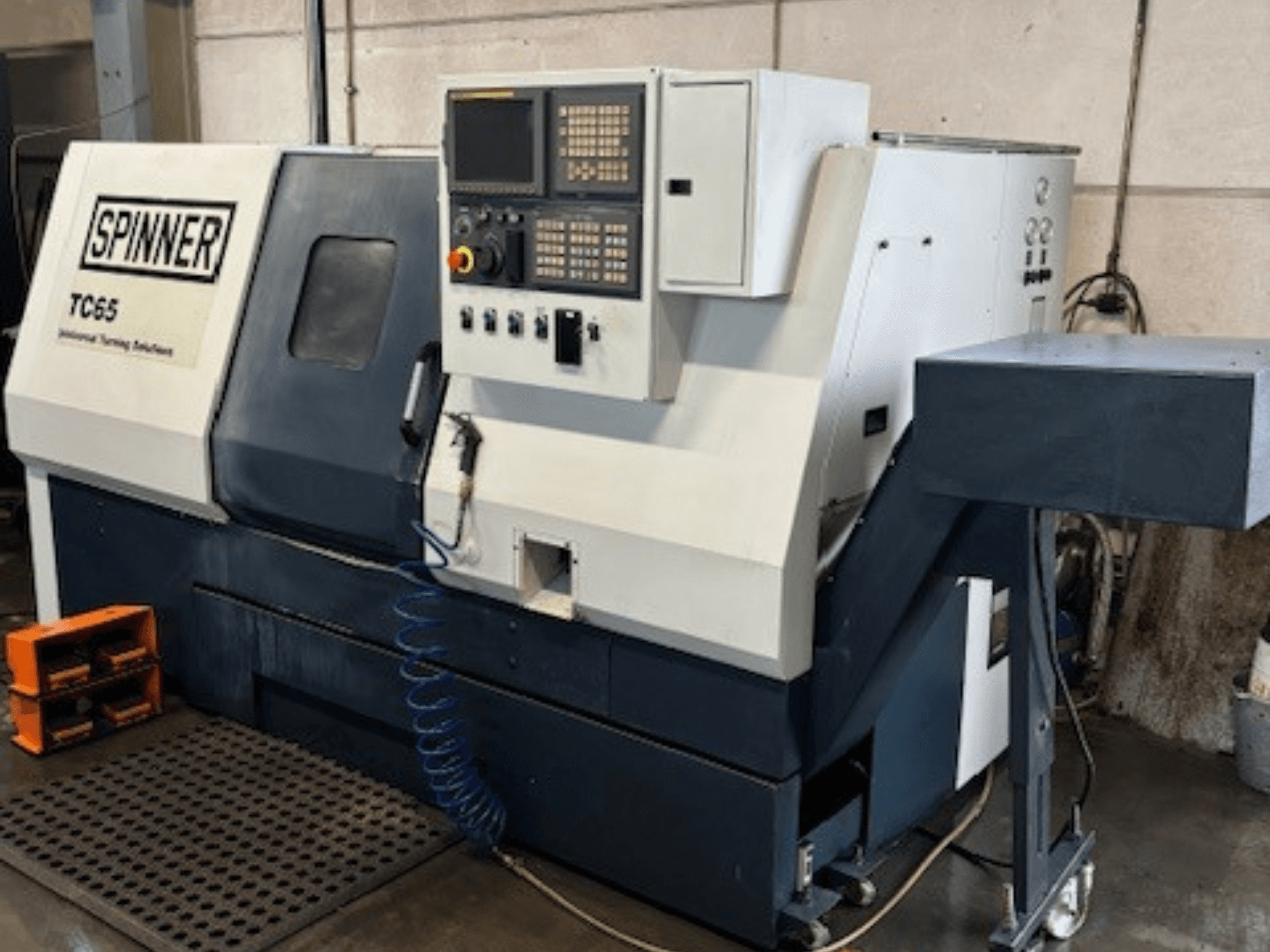 Spinner TC65 endüstriyel torna makinesi, önden görünüm, kontrol paneli, basınçlı hava hattı ve takım depolama alanı.