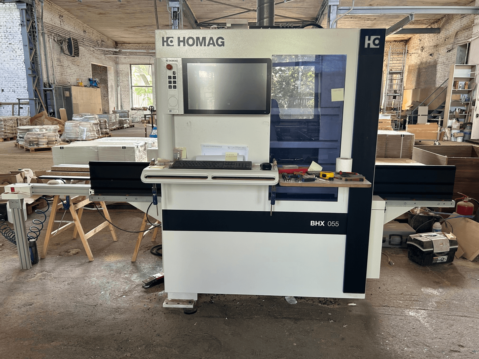 HOMAG WEEKE OPTIMAT BHX 055 CNC İşleme Merkezi, önden görünüm; kontrol paneli ve aletlerin bulunduğu çalışma alanı gösterilmektedir.