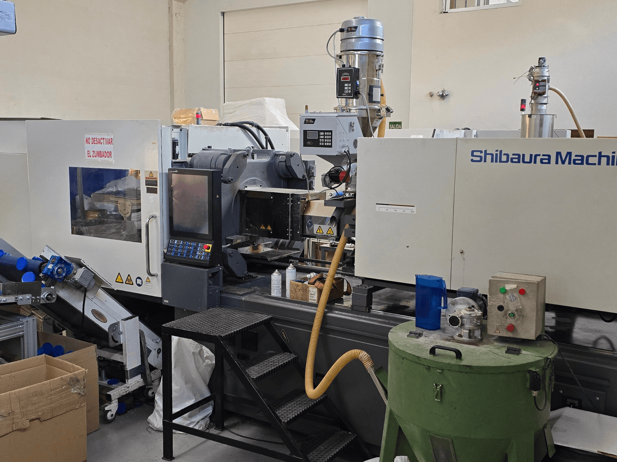 SHIBAURA EC230SXIII-8A elektrikli enjeksiyon kalıplama makinesinin kontrol paneli ve bitişik ekipmanlarla birlikte önden görünümü.