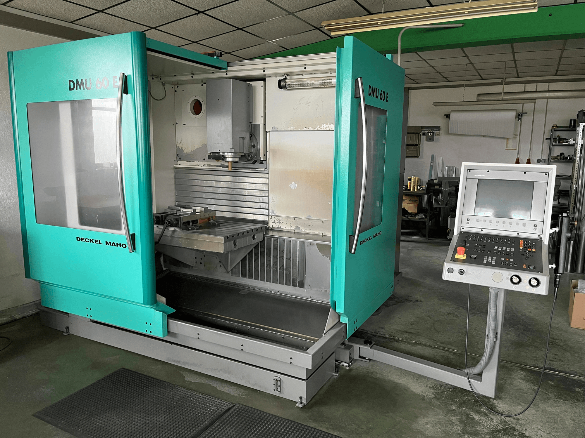 DECKEL DMU 60 E dikey işleme merkezinin önden görünümü, hassas işleme görevleri için kontrol panelini ve iş mili kafasını sergiliyor.