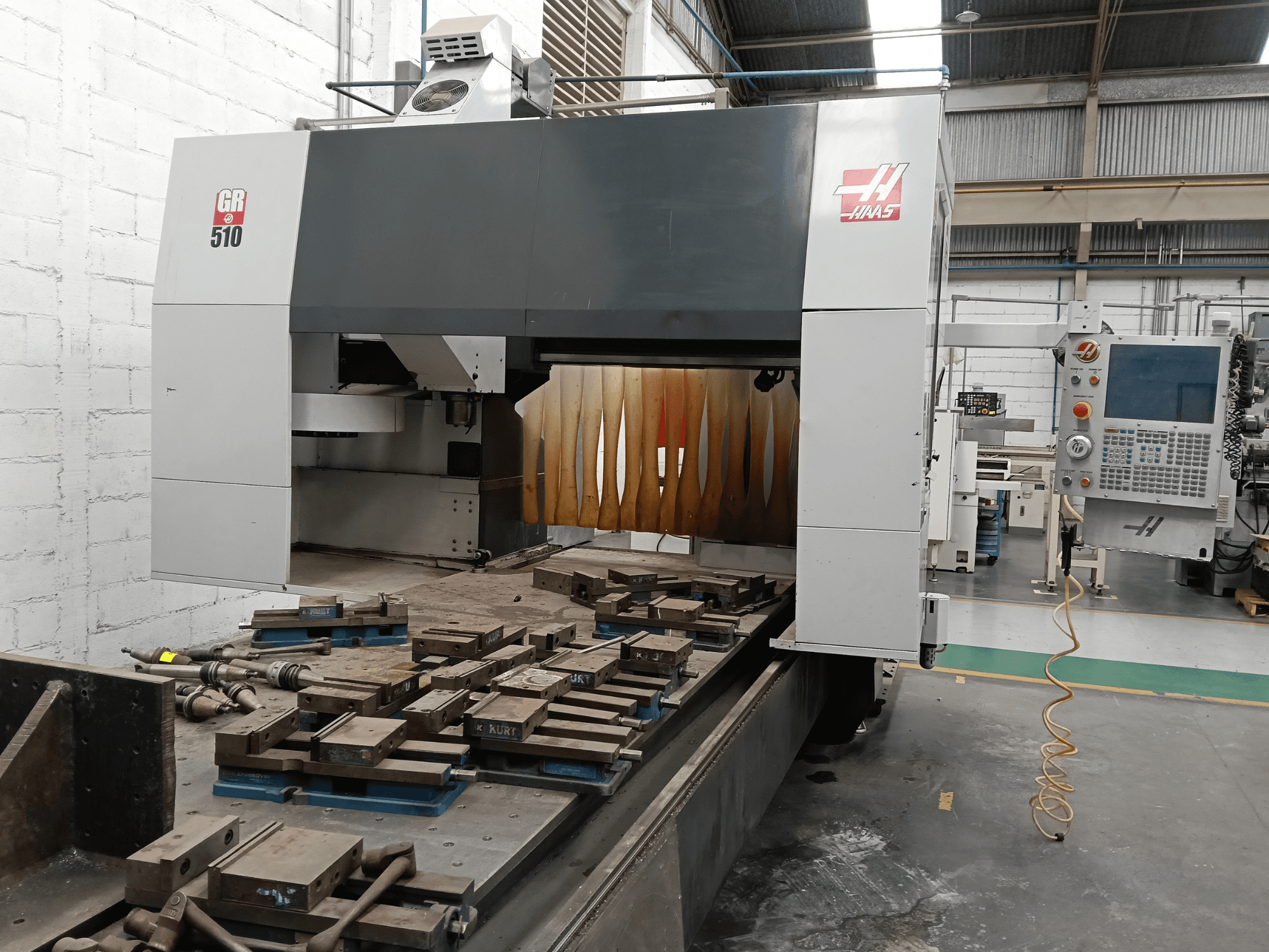HAAS GR-510 portal freze tezgahının önden görünümü; kontrol paneli ve tezgahın üzerindeki işlenmiş iş parçaları görülmektedir.