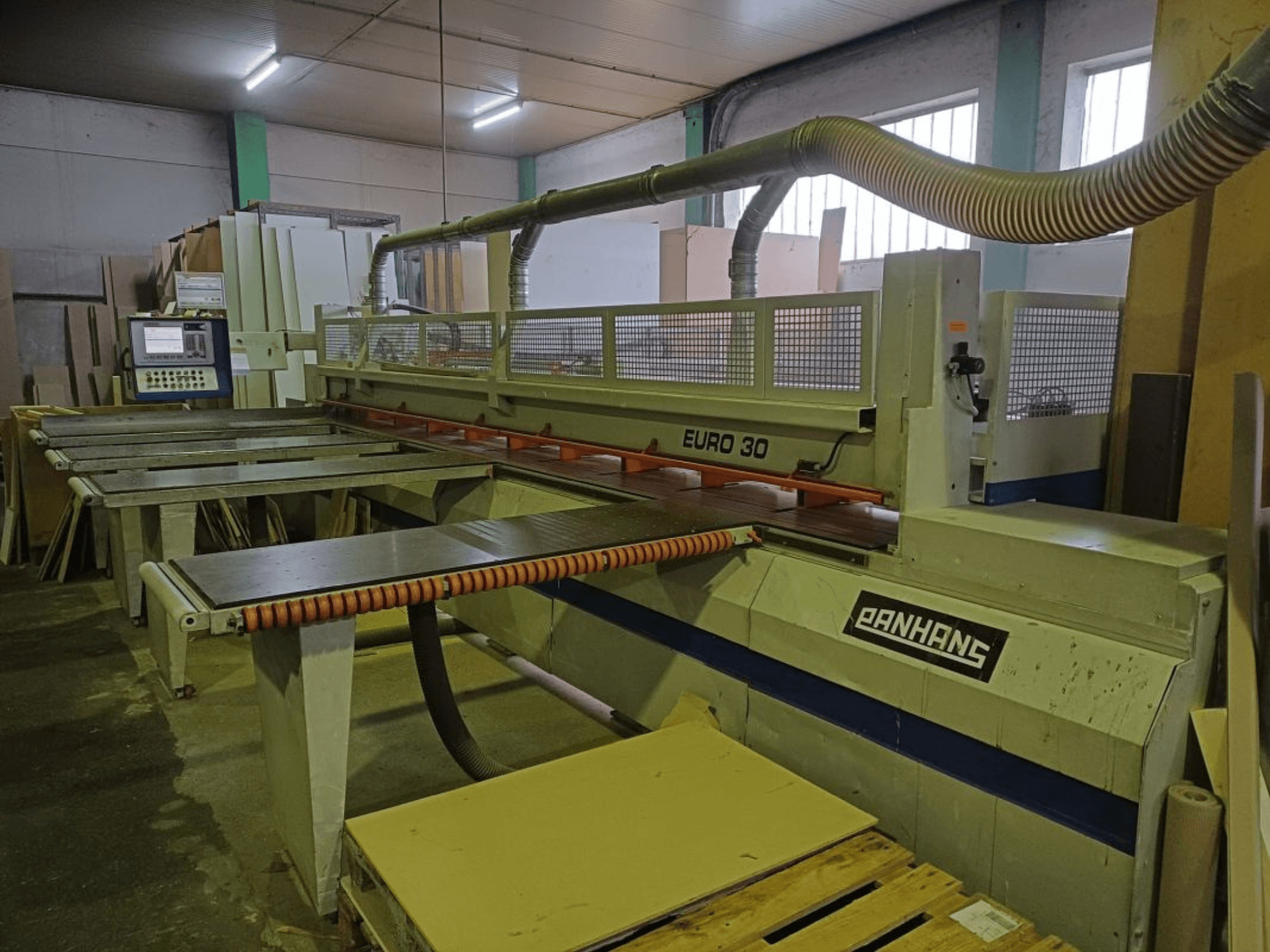 PANHANS EURO 30 panel testerenin kontrol paneli, kesim masası ve toz emme hortumu ile atölye ortamında önden görünümü.