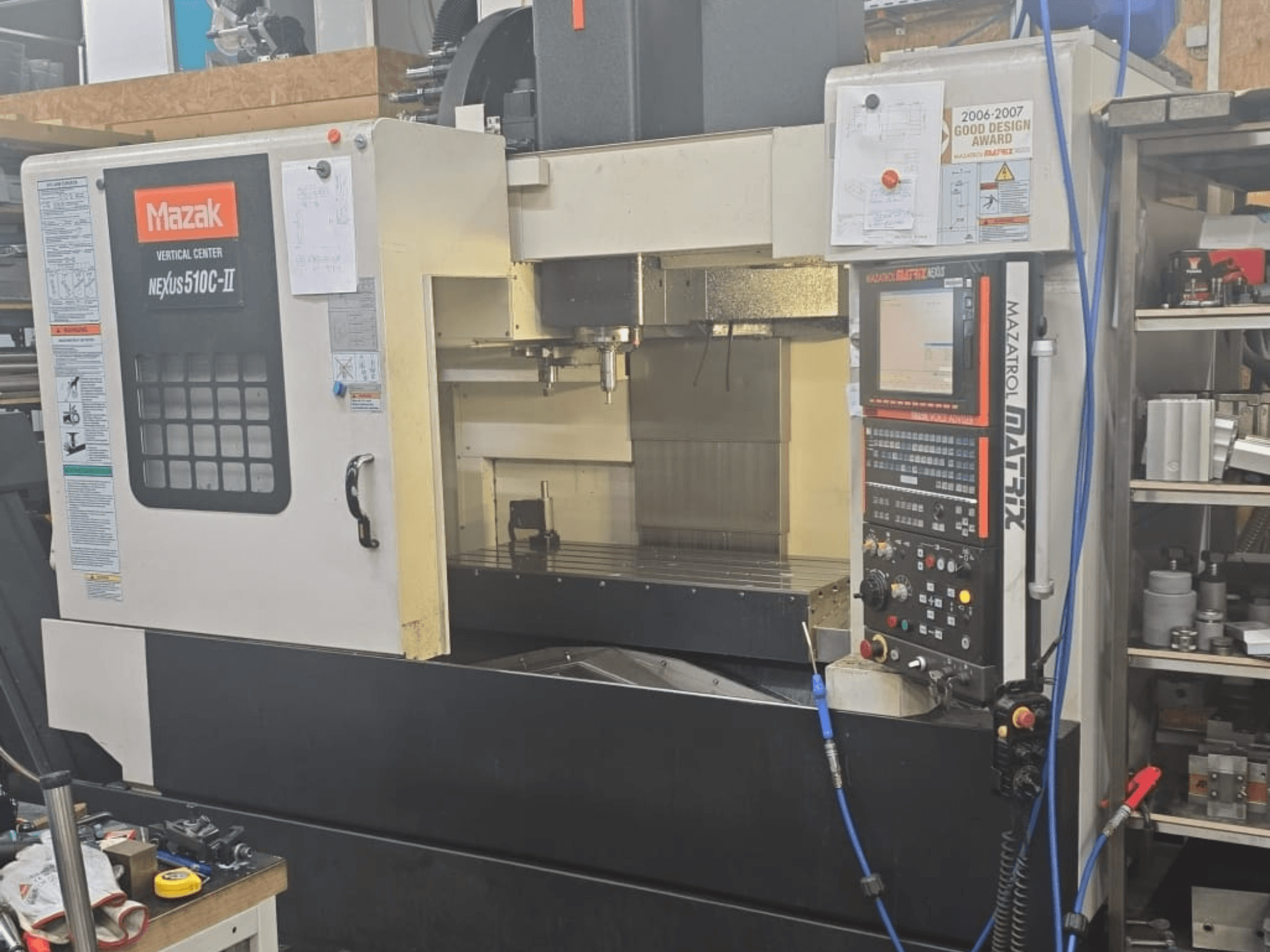 Mazak DİKEY MERKEZ NEXUS 510C-II, kontrol panelini, işleme alanını ve çalışma özelliklerini gösteren önden görünüm.