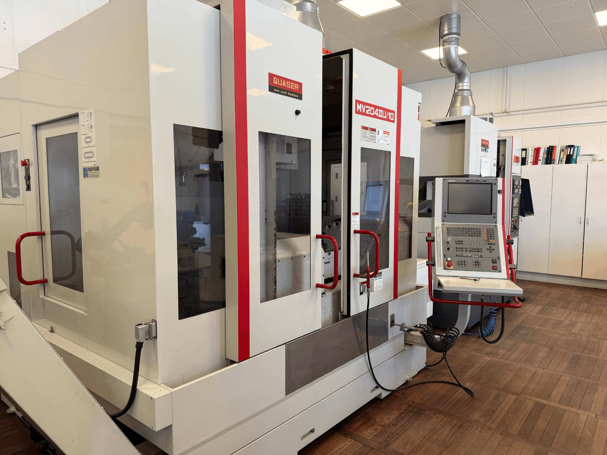 Quaser MV204U/10 Üniversal İşleme Merkezinin önden görünümü, kontrol paneli ve çift makine kurulumu.
