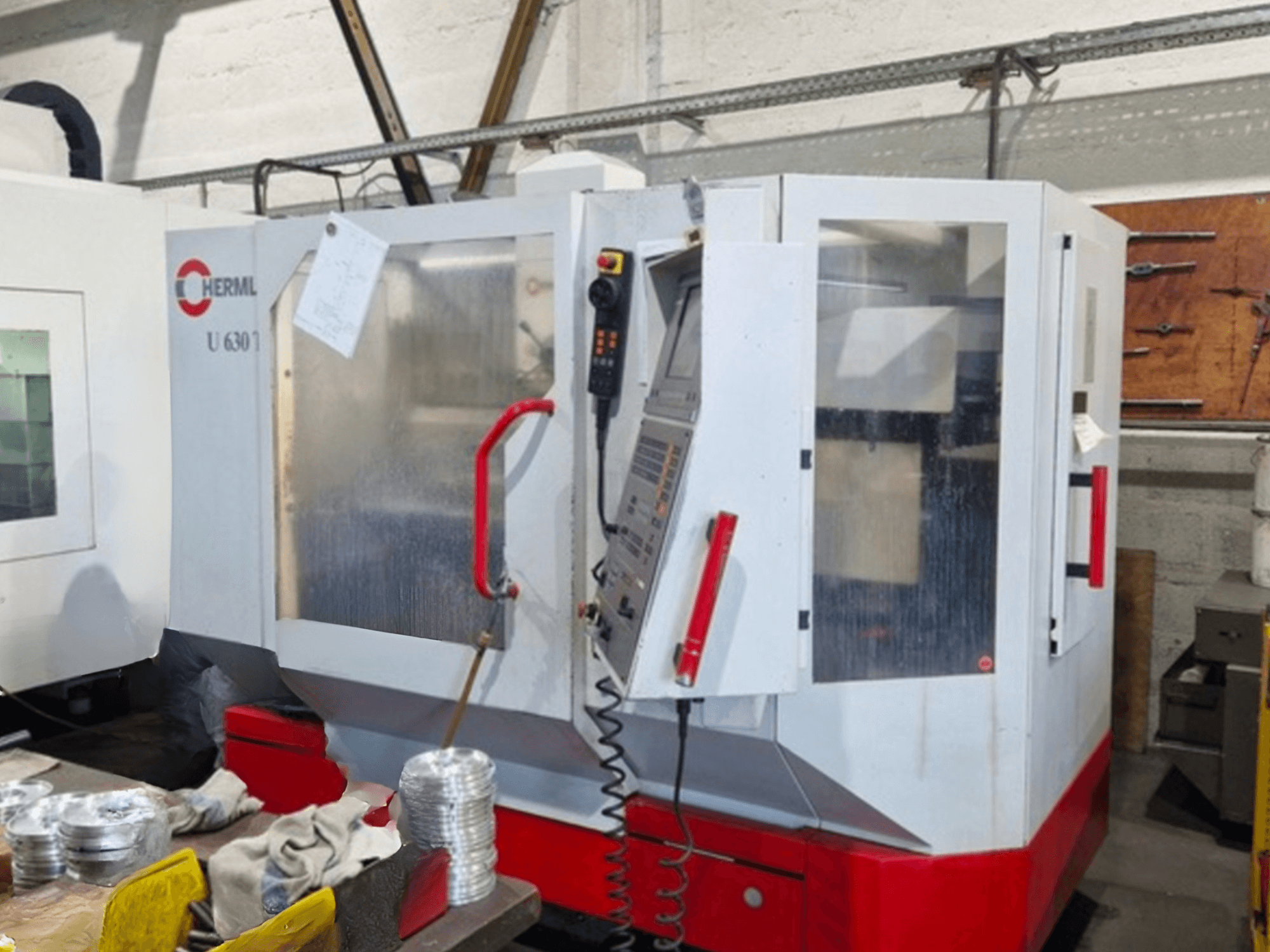 HERMLE U 630 T üniversal işleme merkezinin önden görünümü, açık bir kapı ve görünür düğmeler ve aletler içeren kontrol paneli.