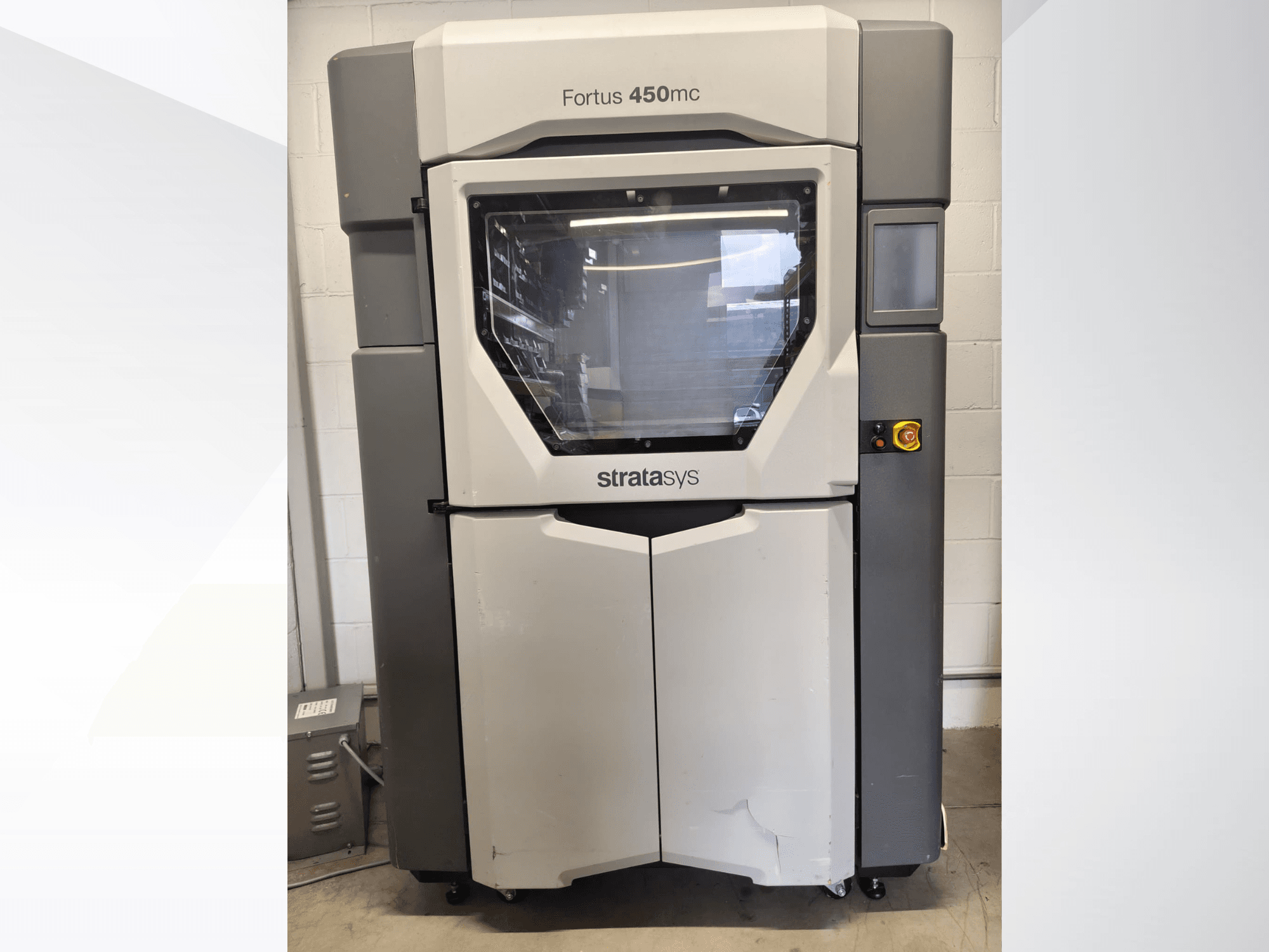 Stratasys Fortus 450mc plastik işleme makinesi, önden görünüm; geniş bir pencere, kontrol paneli ve endüstriyel tasarımıyla öne çıkıyor.
