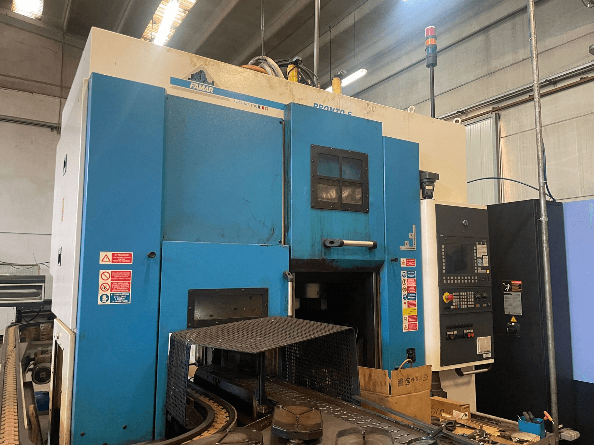 Famar Pronto 6 dikey torna makinesi atölyede, yandan görünüm, kontrol panelini, çalışma özelliklerini ve güvenlik etiketlerini gösterir.