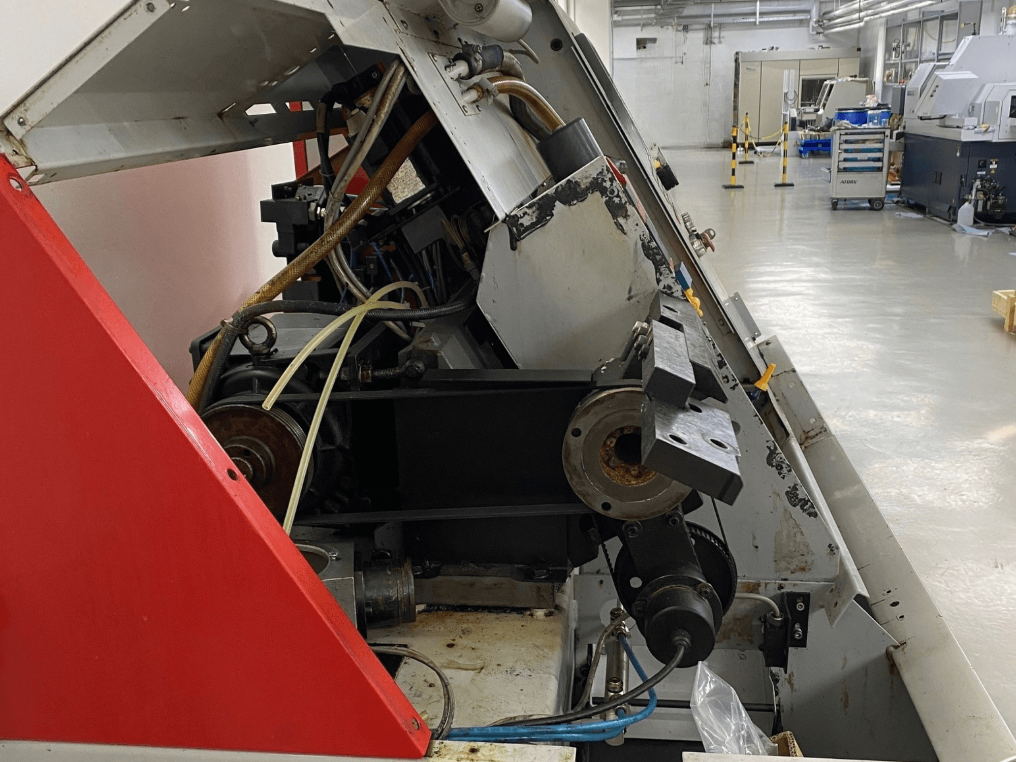 EMCO Emcoturn 325 yatay tornalama makinesi, endüstriyel ortamda tahrik bileşenlerini ve hidroliği gösteren yandan görünüm.