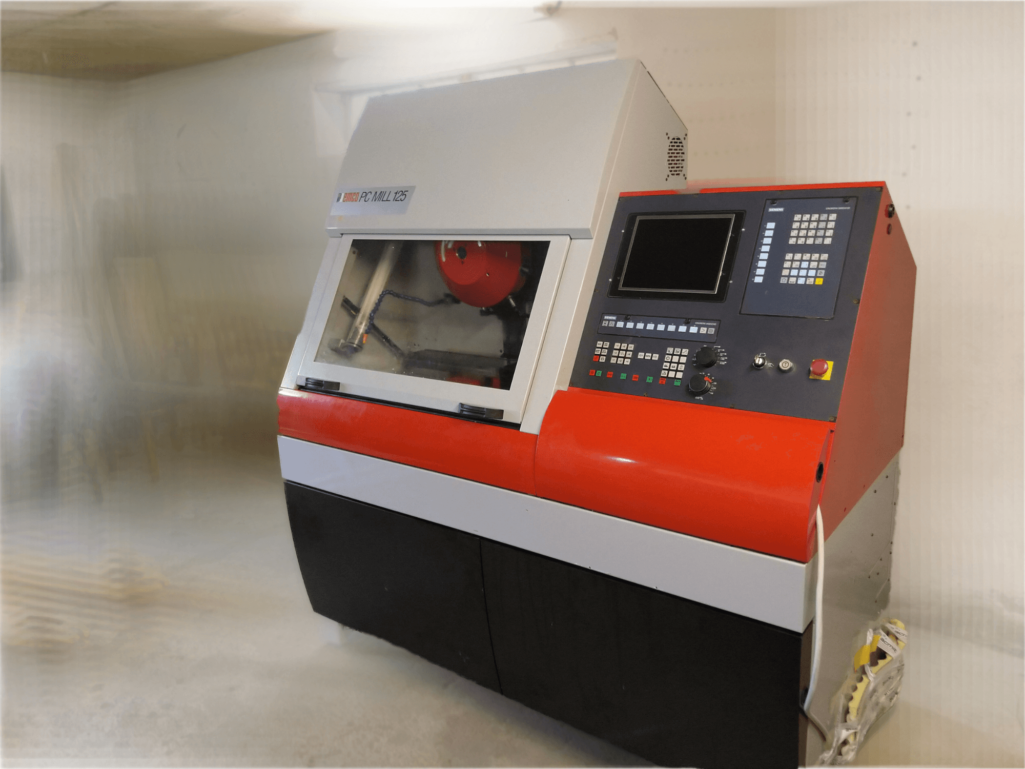 EMCO PC MILL 125 dikey işleme merkezi, kontrol paneli ve görünür işleme alanı ile önden görünüm.