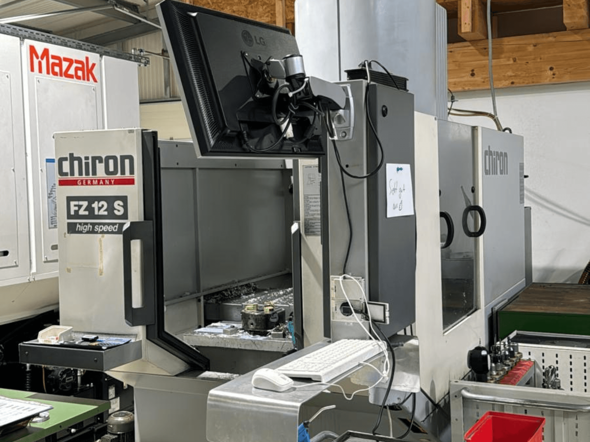 CHIRON FZ 12 S yüksek hızlı işleme merkezinin kontrol ekranı ve işleme sürecinden kalan döküntülerle dikey görünümü.