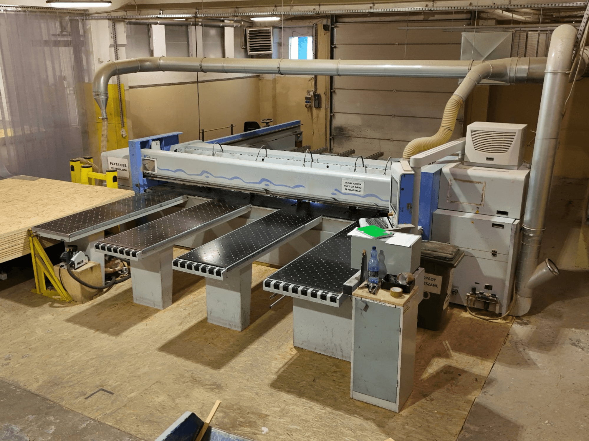 Bir atölyede bulunan HOLZMA HPP 350/43/38 panel testere, yukarıdan bakıldığında kesme alanı ve destek masaları görülmektedir.