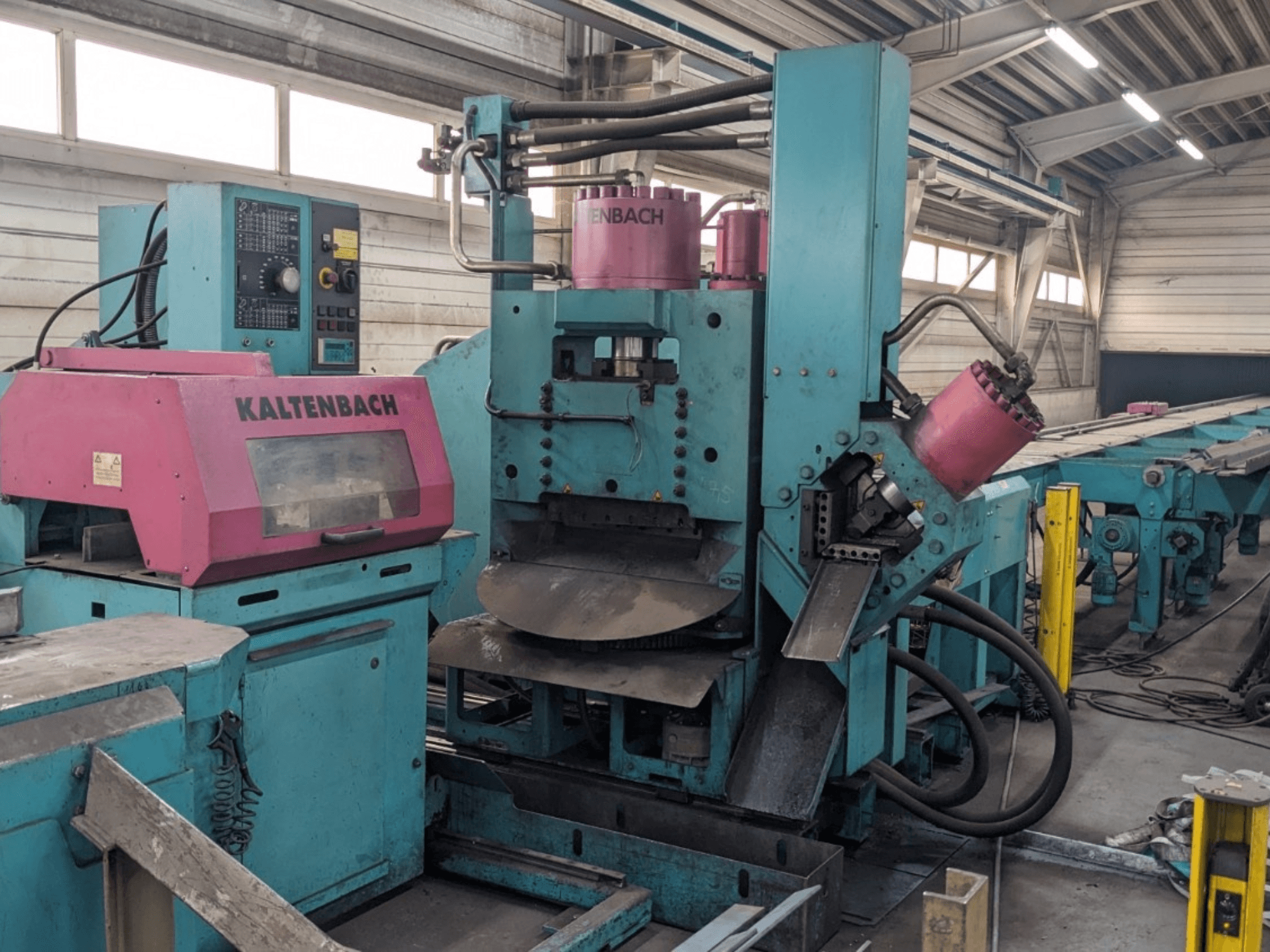 KALTENBACH deniz mavisi ve pembe renkli endüstriyel makine, önden görünüm, kontrol paneli ve hidrolik bileşenlere sahiptir.