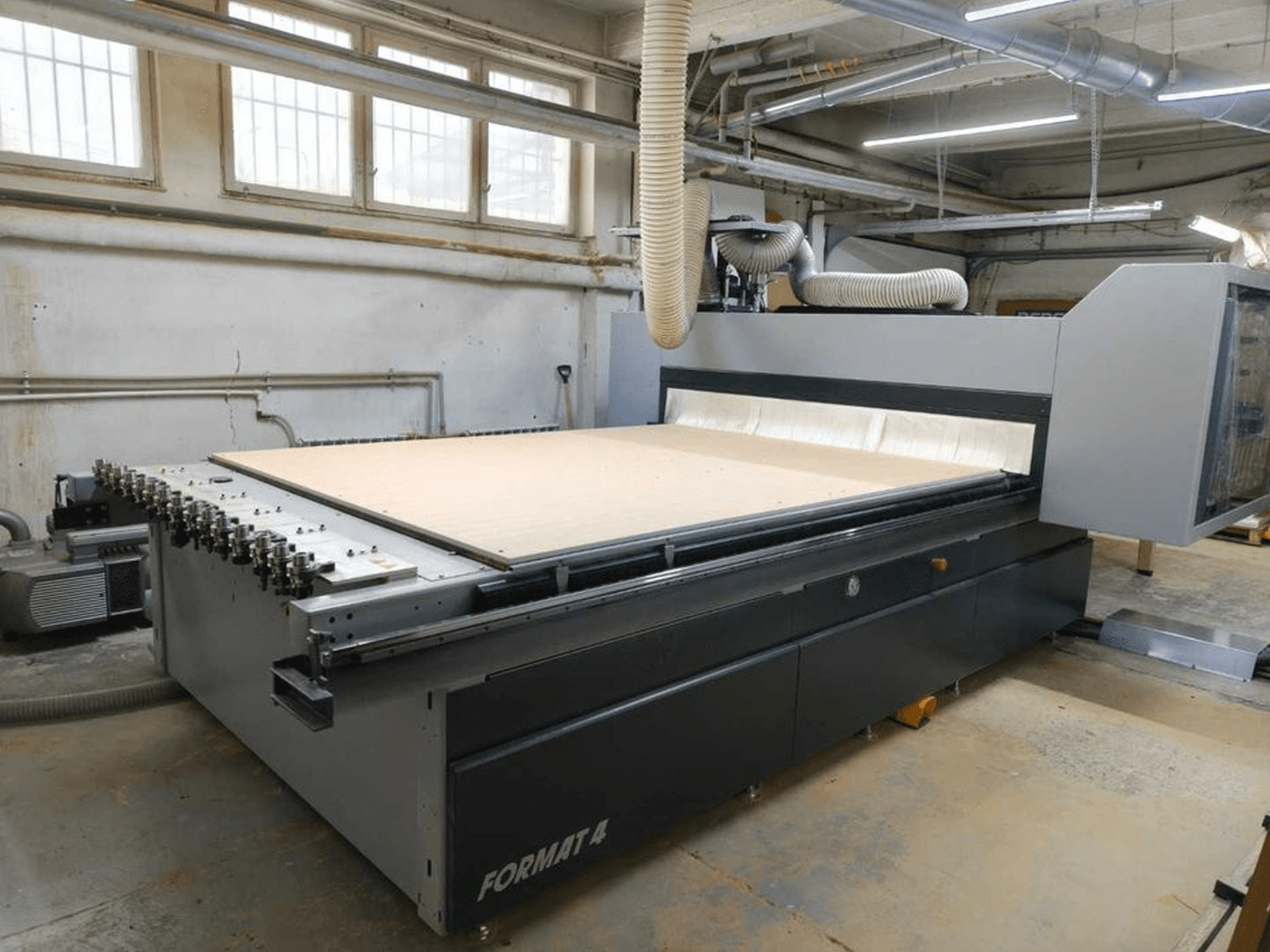 CNC Router FORMAT4 Profit H80 21.31 atölyede, geniş kesme yüzeyi ve toz emme için görünür hortum ile yandan görünüm.
