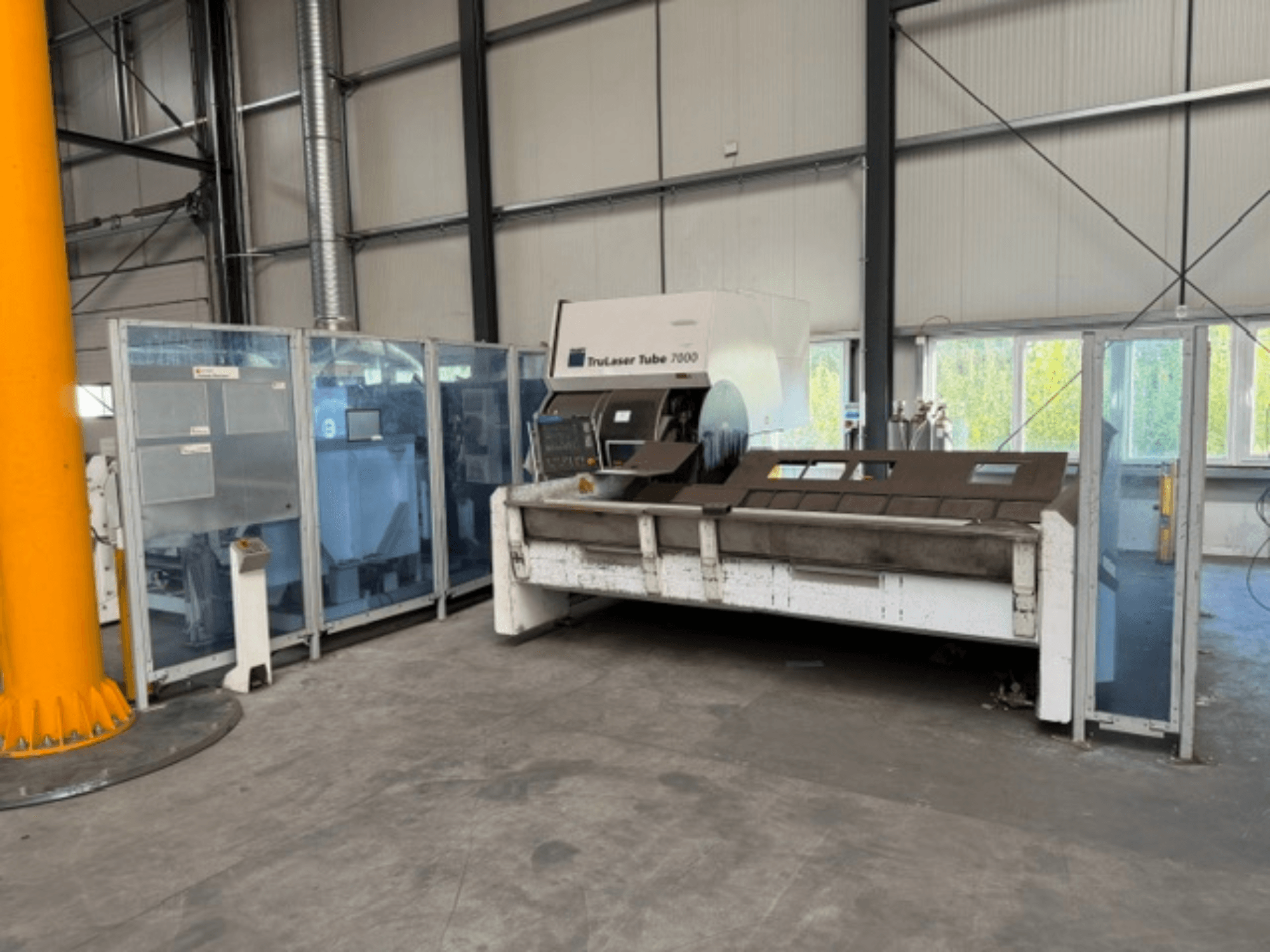 TRUMPF’ın TruLaser Tube 7000 modeli; iyi aydınlatılmış bir endüstriyel ortamda, çalışma kontrolleri görülebilen bir boru kesme makinesinin önden görünümü.