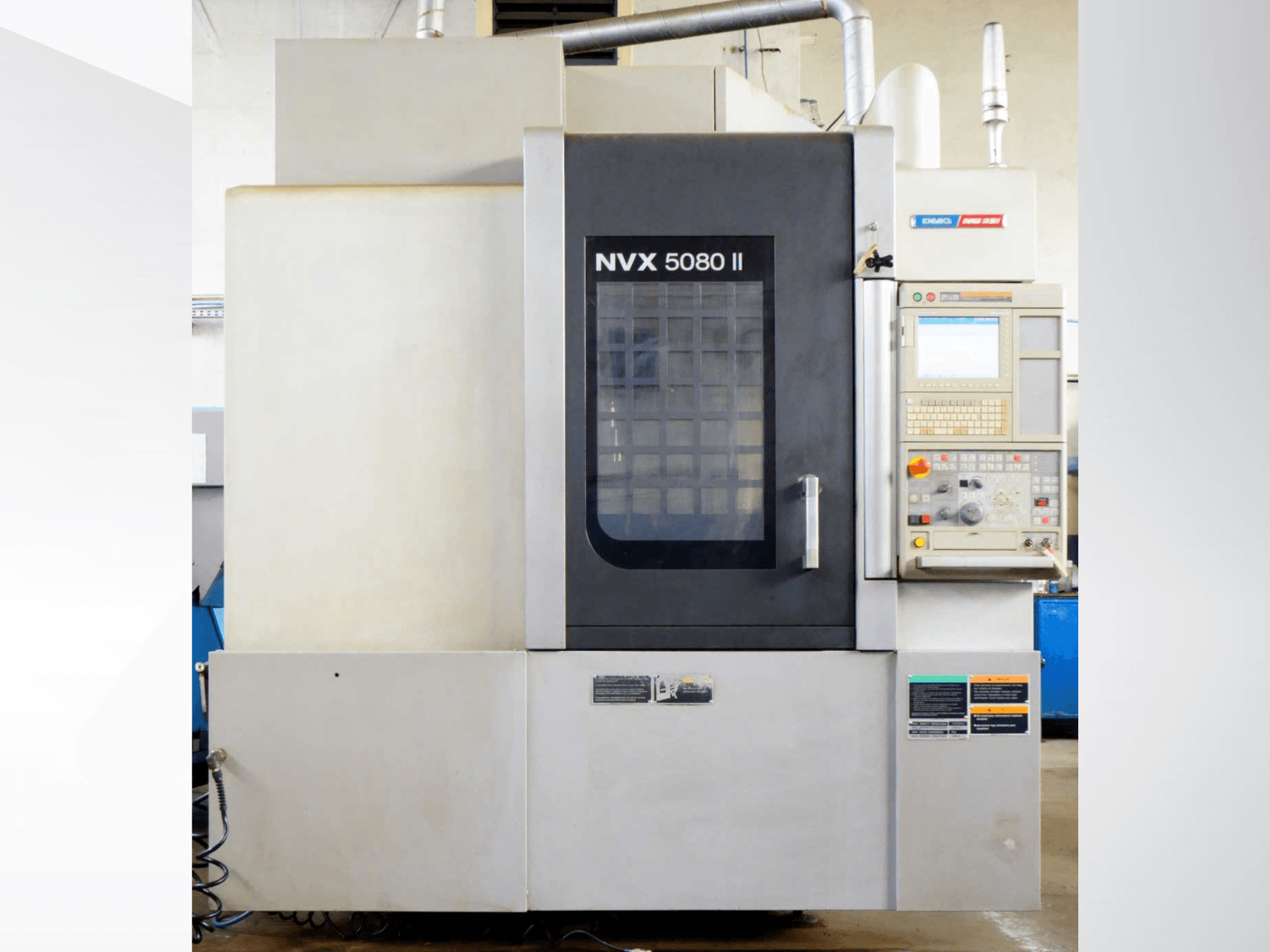 DMG Mori Seiki NVX 5080 II dikey işleme merkezi, önden görünüm; kontrol paneli ve ızgaralı kapı tasarımıyla.