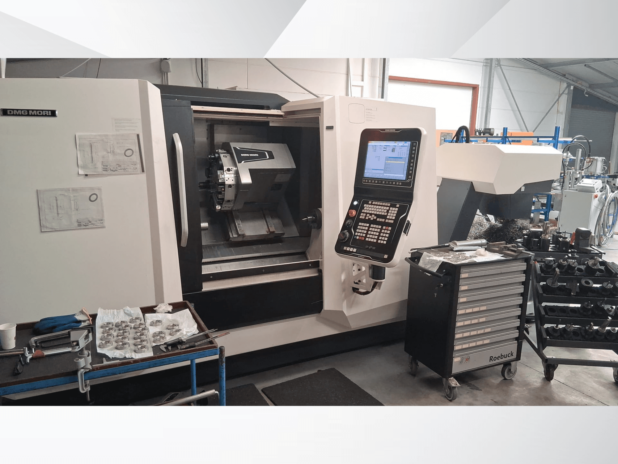 DMG MORI CLX450 yatay tornalama makinesinin önden görünümü, kontrol paneli, çalışma alanı, aletler ve metal parçalar.
