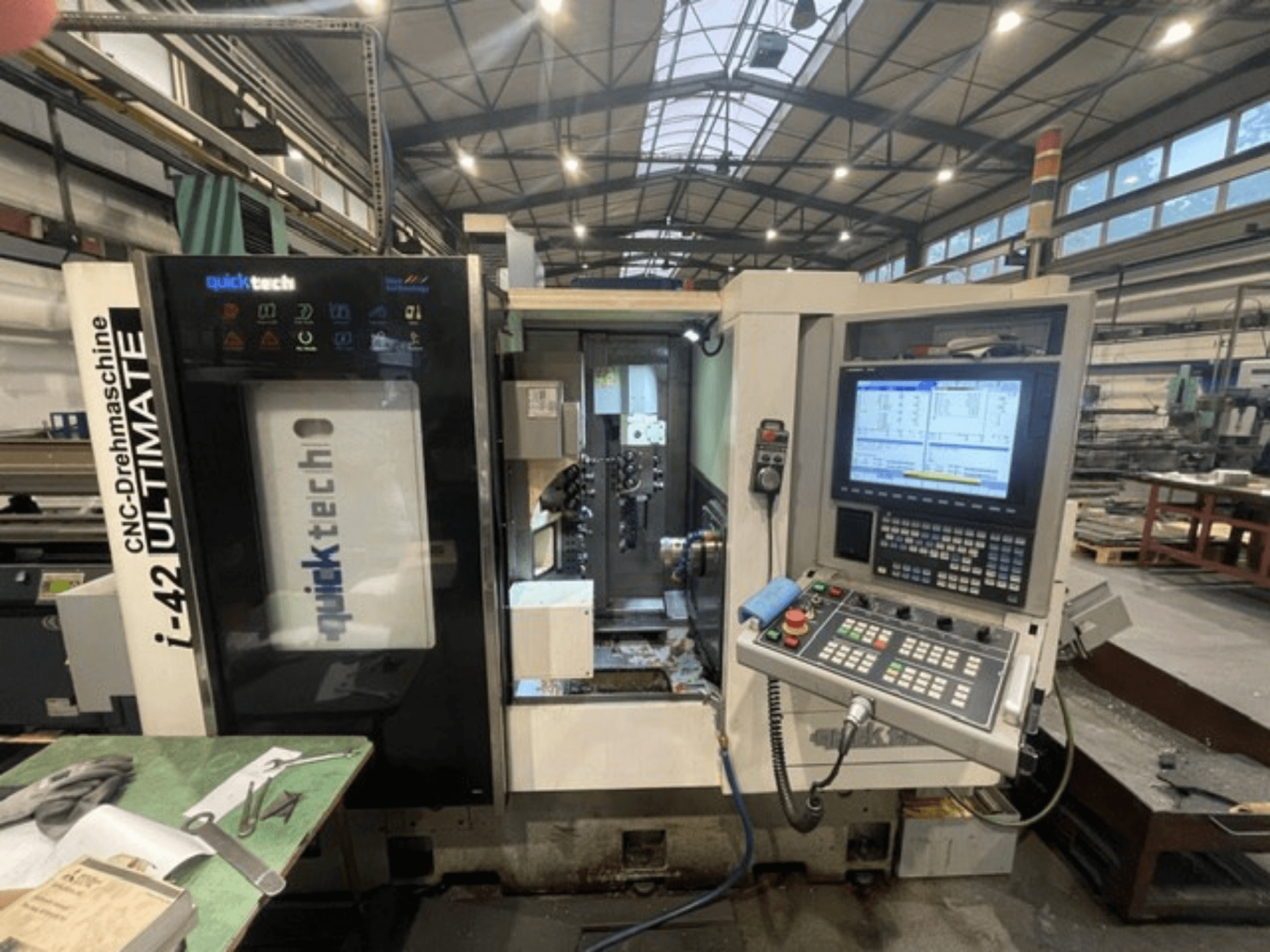 Quick-Tech I-42U İsviçre Tipi Torna Makinesi, önden görünüm, atölye ortamında kontrol panelini ve CNC arayüzünü gösterir.