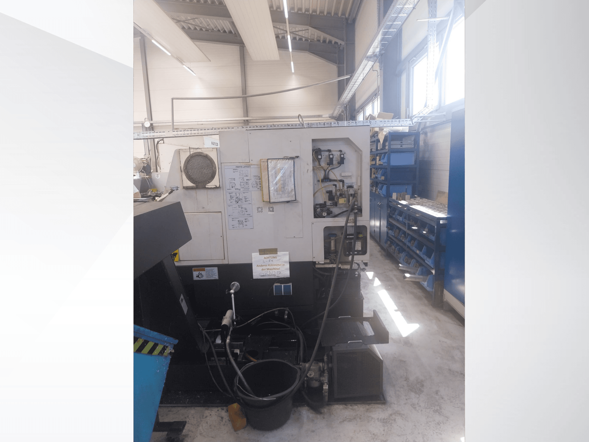 Mazak QUICK TURN NEXUS 200 MS; bir atölye ortamında kontrol paneli, hortumlar ve takım alanını gösteren yandan görünüm.