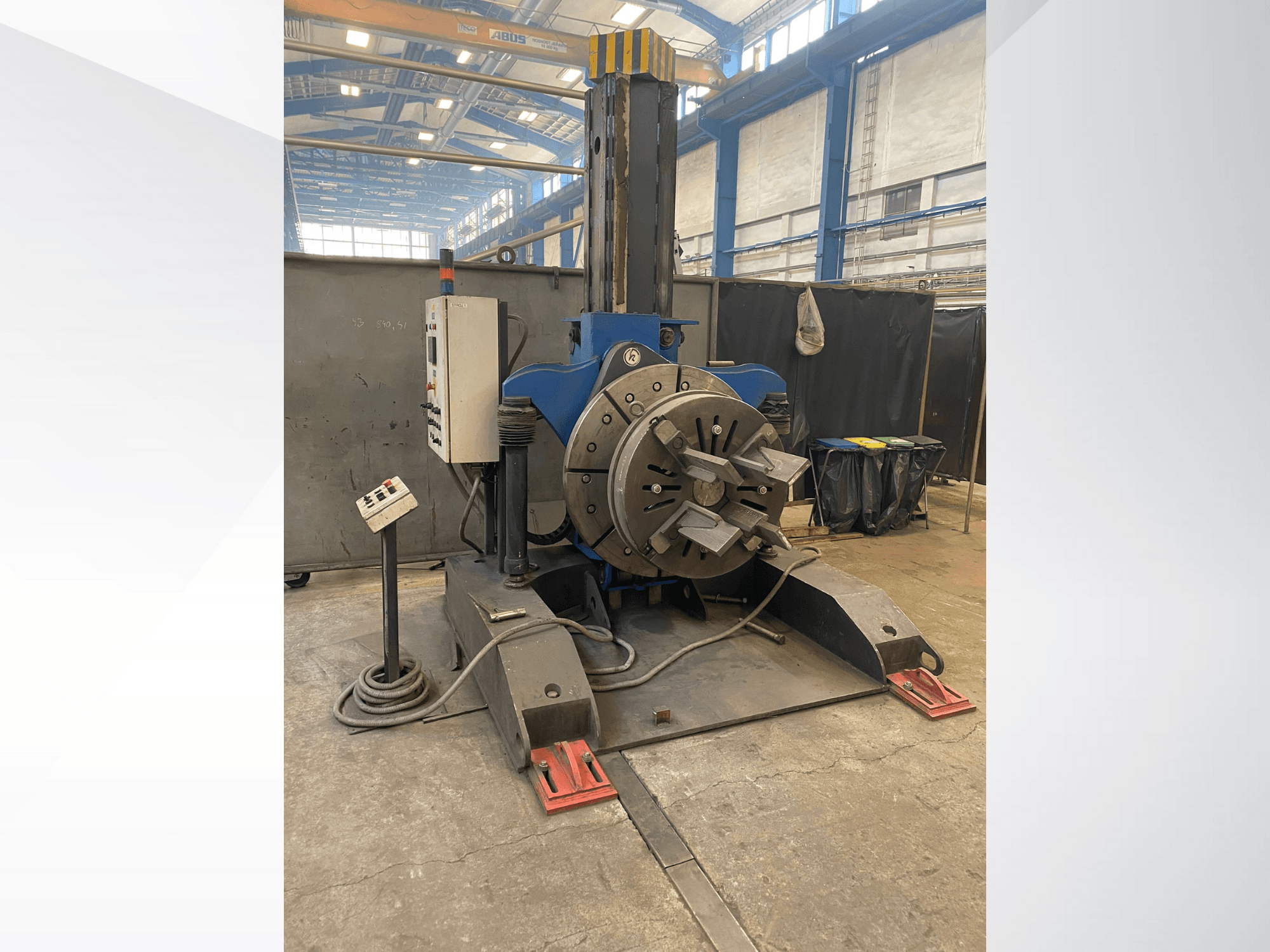 Yuvarlak döner kafalı ve kontrol panelli mavi endüstriyel torna makinesi, yandan görünüm, bir atölye ortamında.