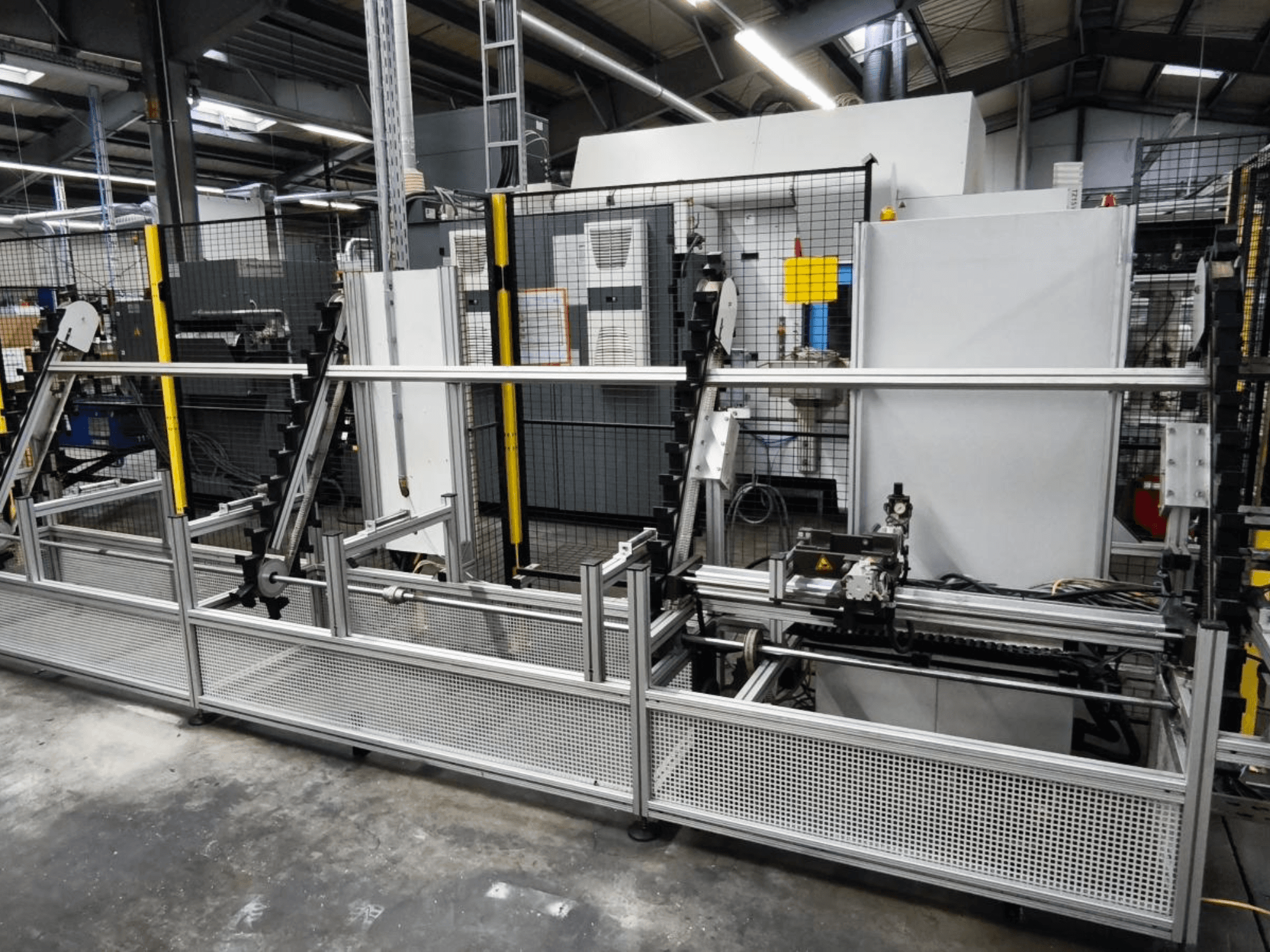 LOHMEIER Schräglademagazin iş parçası taşıma sistemi önden görünümde, metal yapısı ve entegre mekanik bileşenleri sergileniyor.