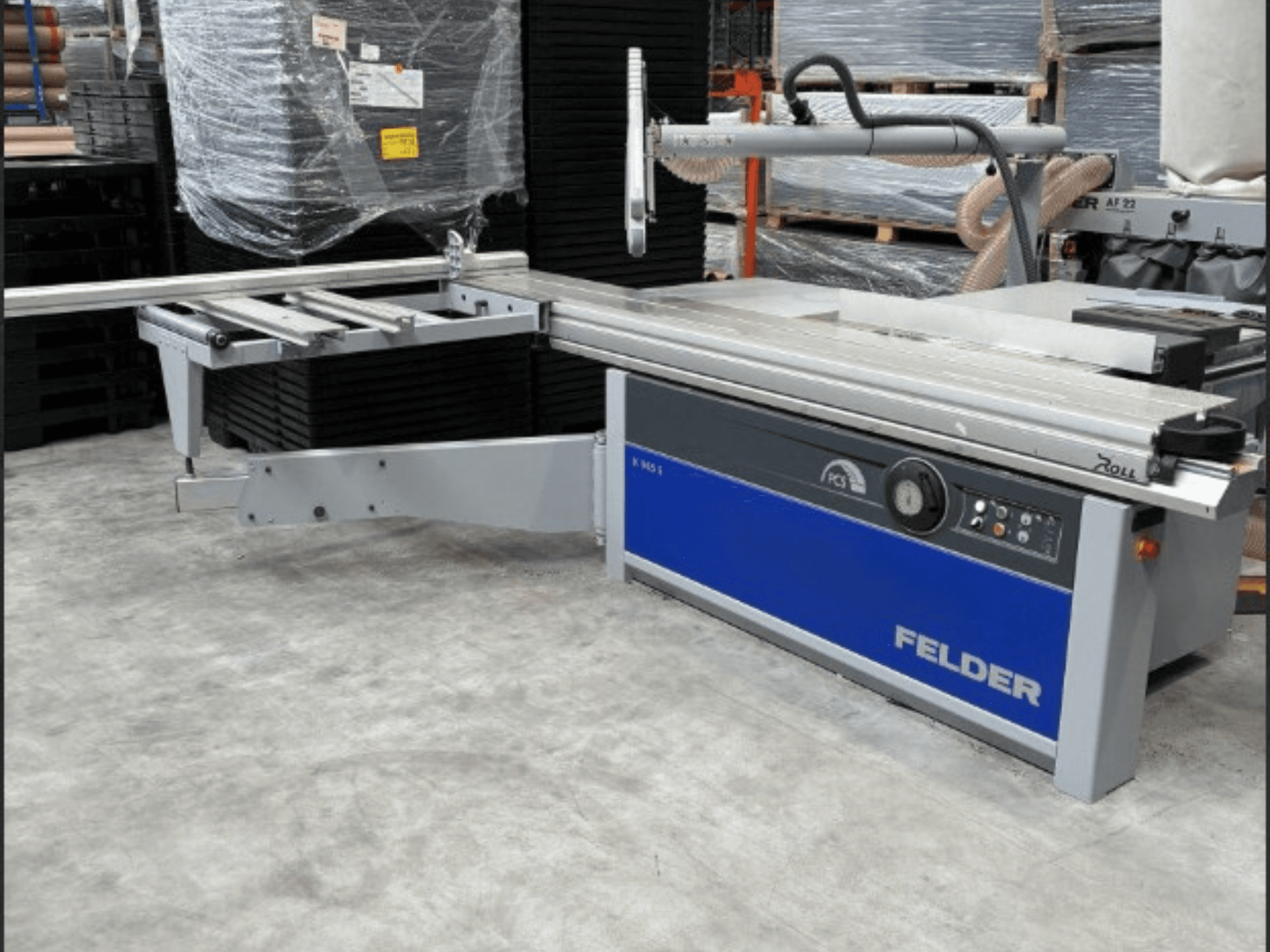 FELDER K 945S panel testere, ayarlanabilir masa ve kontrol paneli ile önden görünüm, bir depo ortamında.