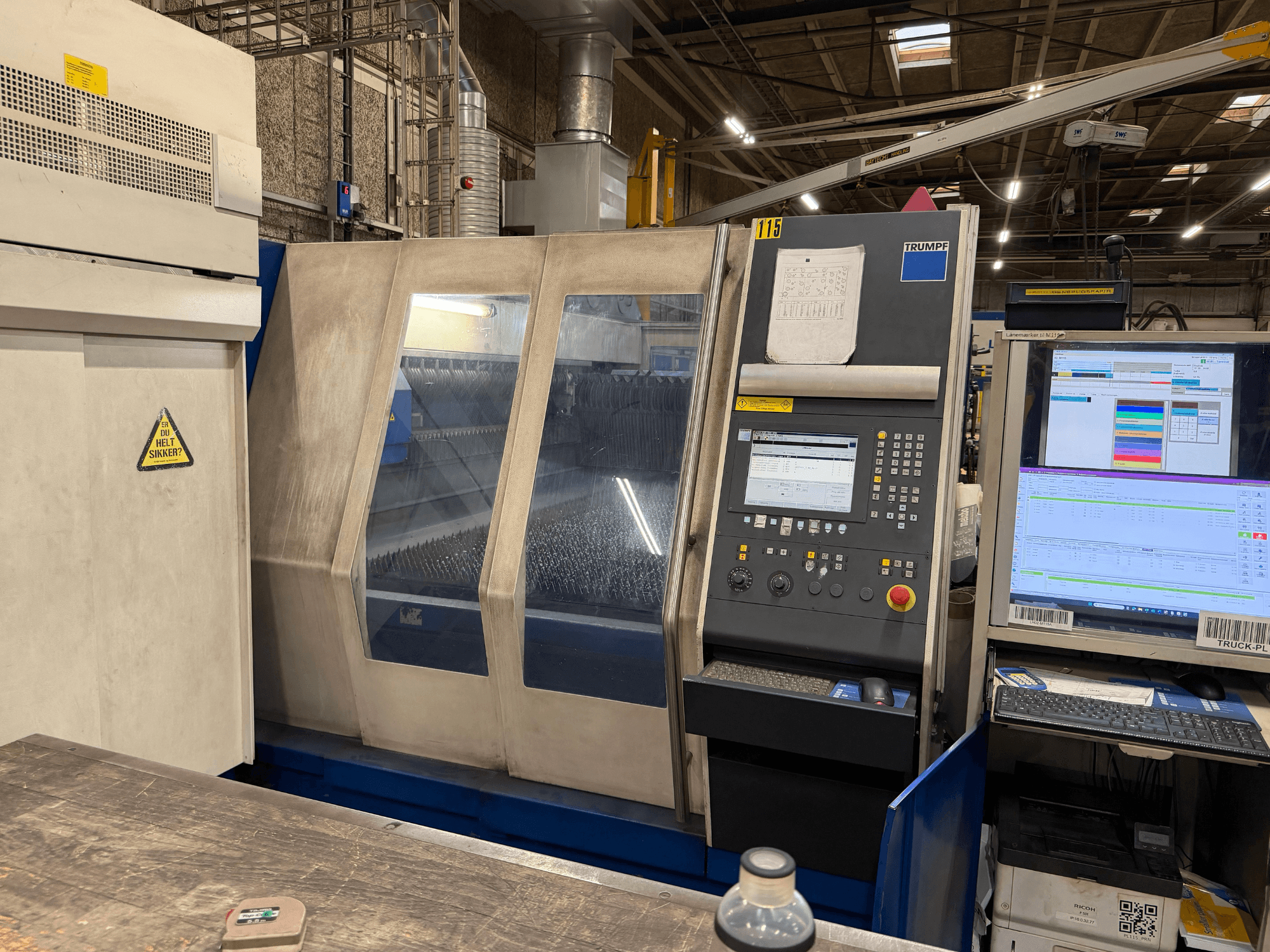 Fabrika ortamına yerleştirilmiş, kontrol panelli ve dijital göstergeli bir Trumpf endüstriyel lazer makinesinin önden görünümü.