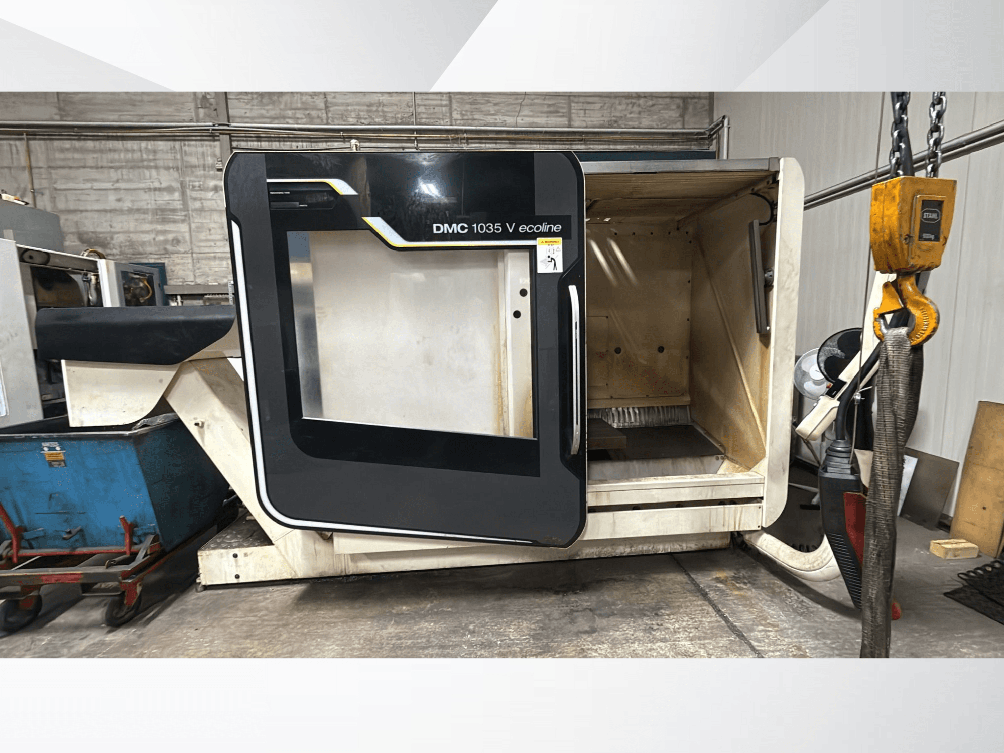 DMC 1035 V ecoline CNC makinesi, önden görünüm, boş bir iç mekanı ve kontrol panelini ortaya çıkaran açık kapıya sahiptir.