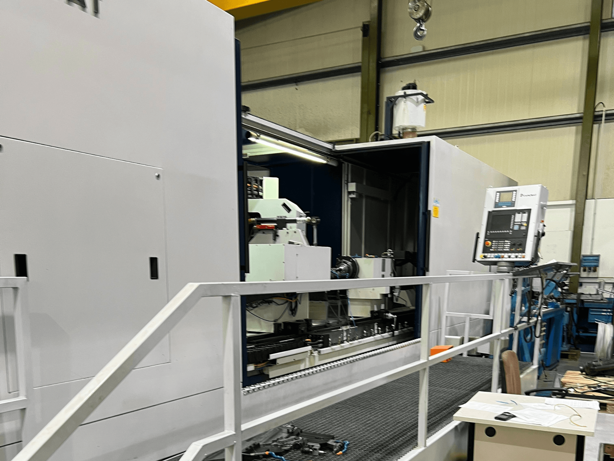 Kontrolleri, takım tutucuyu ve içindeki ana bileşeni gösteren açık yan görünümlü CNC işleme merkezi. Marka detayları görünmüyor.