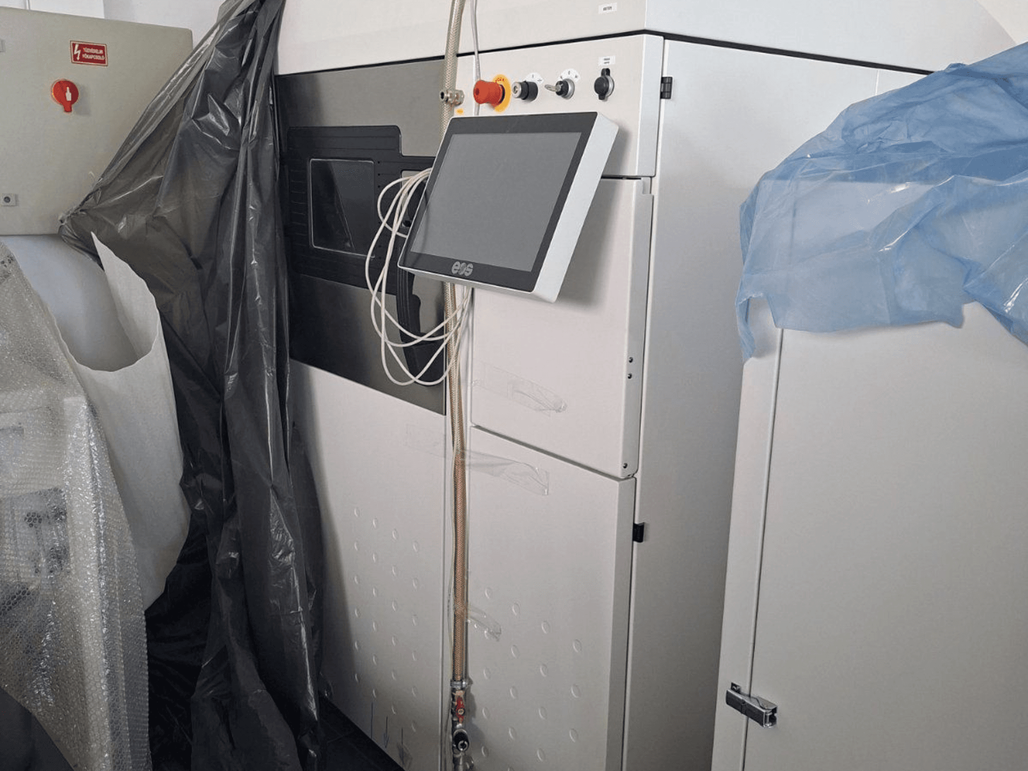 Dokunmatik ekran, kontrol paneli ve koruyucu kaplamalar içeren EOS M 290 metal 3D yazıcının önden görünümü.