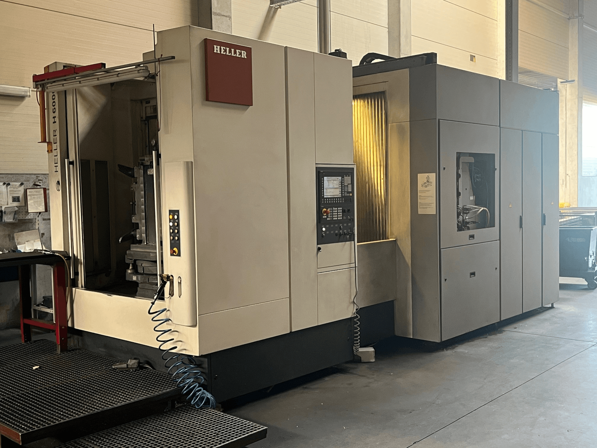 HELLER H6000 yatay işleme merkezinin önden görünümü; kontrol paneli, soğutma sıvısı hortumu ve makine tasarımı görülmektedir.